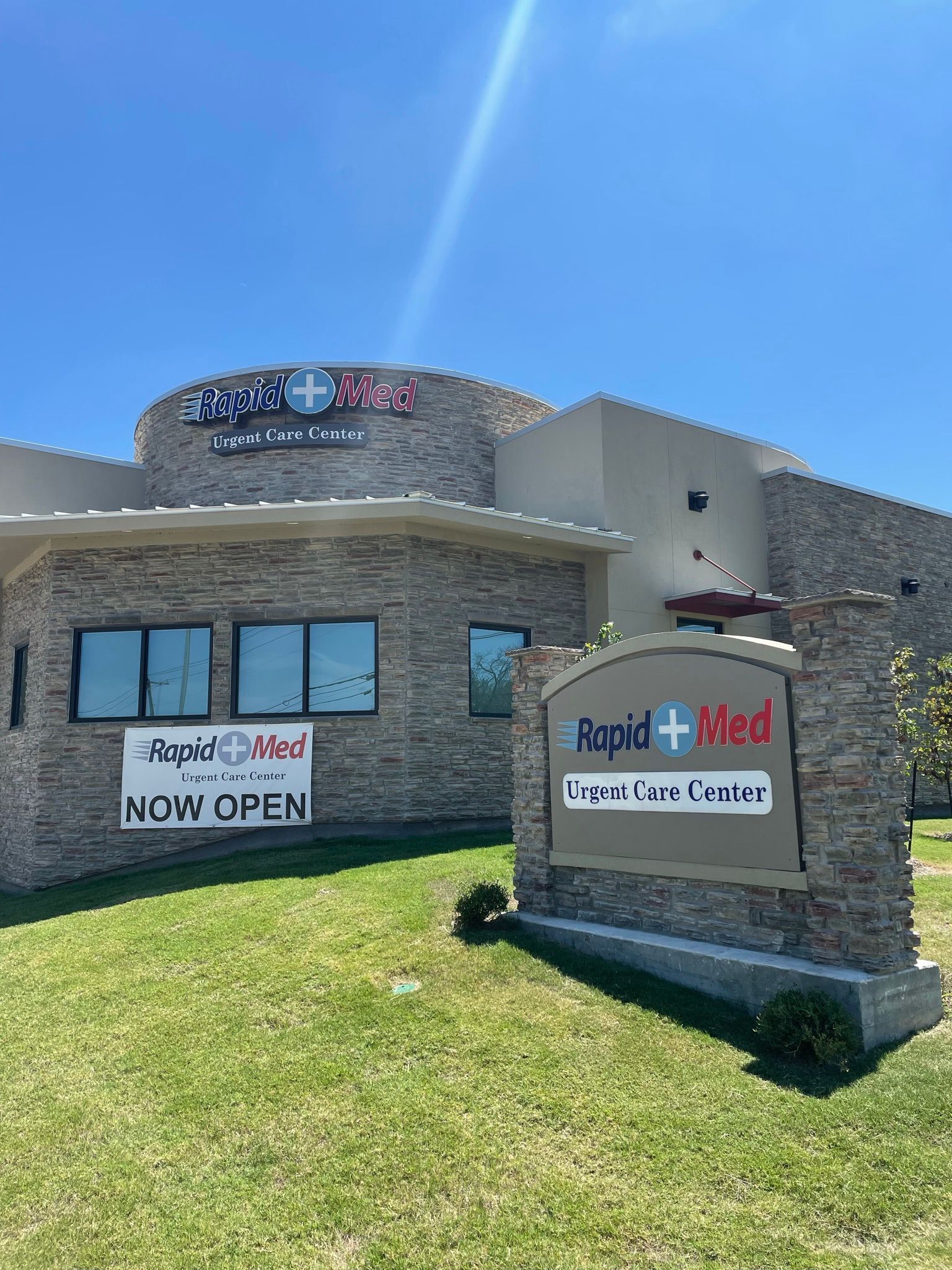 Rapid Med Urgent Care in Argyle, TX with exterior channel letters, a monument sign, and a grand-opening banner.