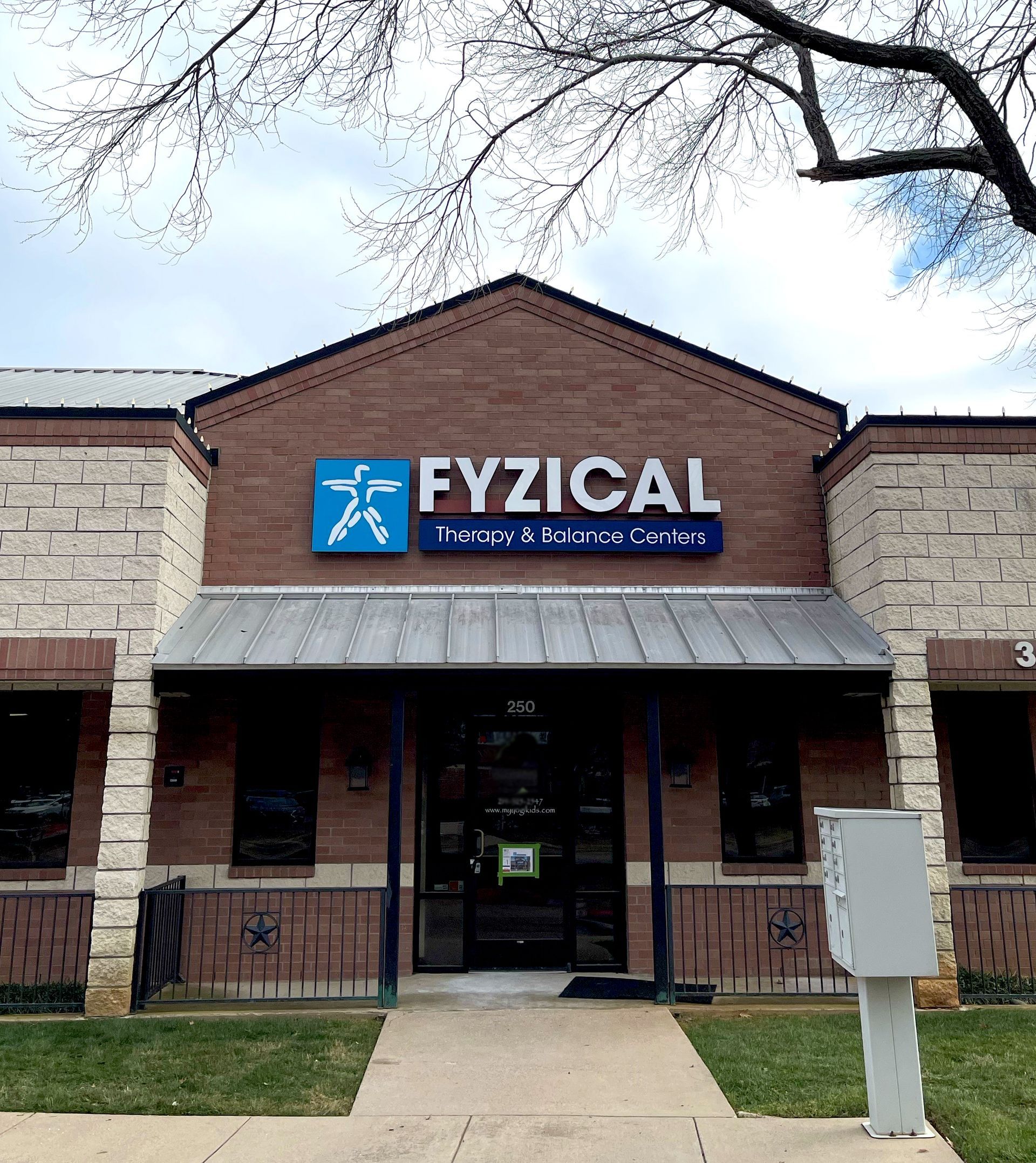 Exterior of a Fyzical physical therapy clinic with a blue sign over the entrance.