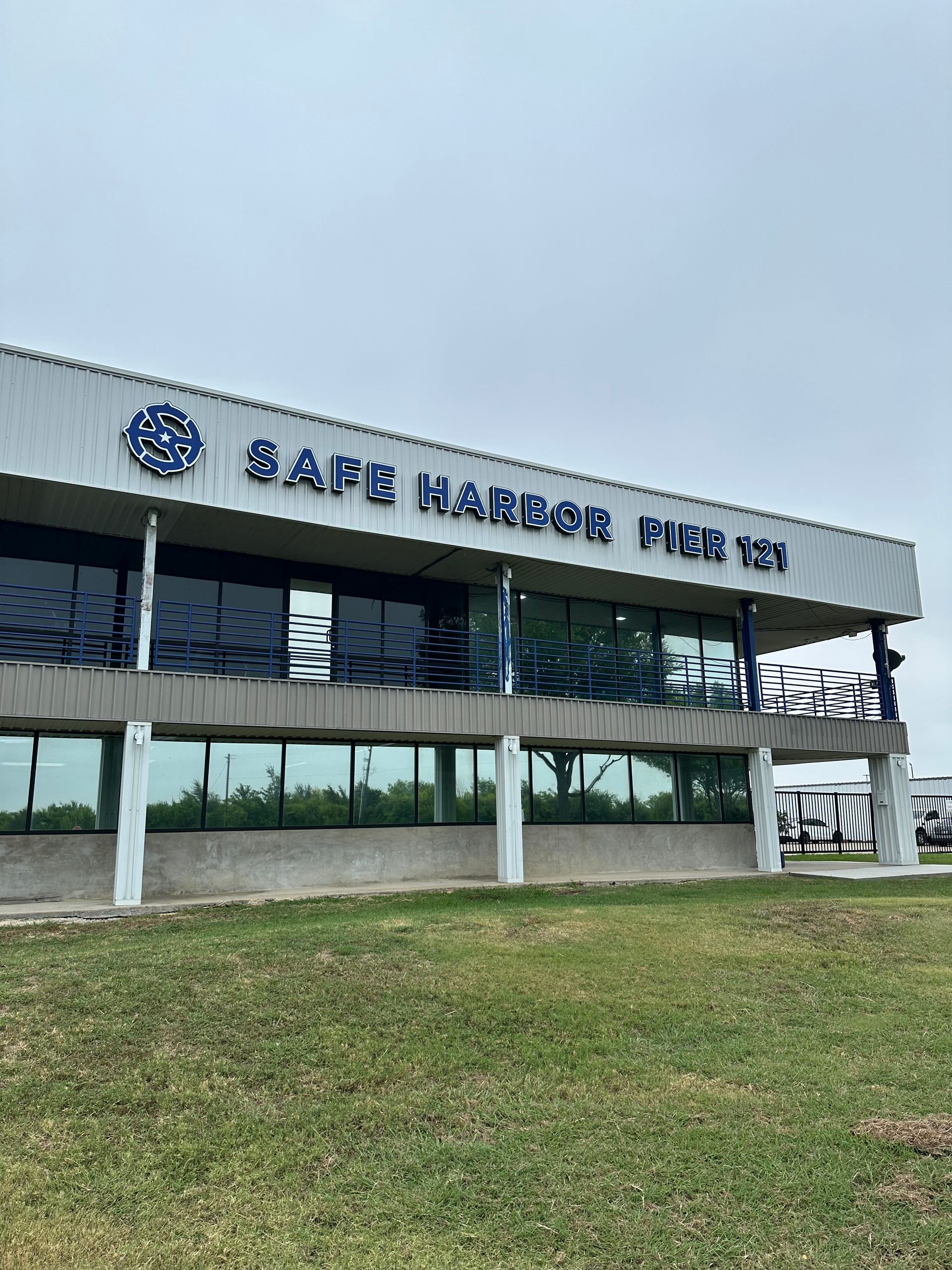 Safe Harbor Pier 17 building with blue sign against a cloudy sky.