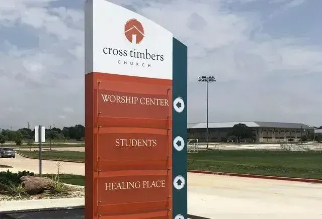 Sign for Cross Timbers Church with directions to worship center, student area, and healing place.