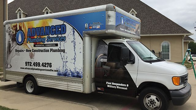 White plumbing service truck with blue Advanced branding parked in a suburban driveway.