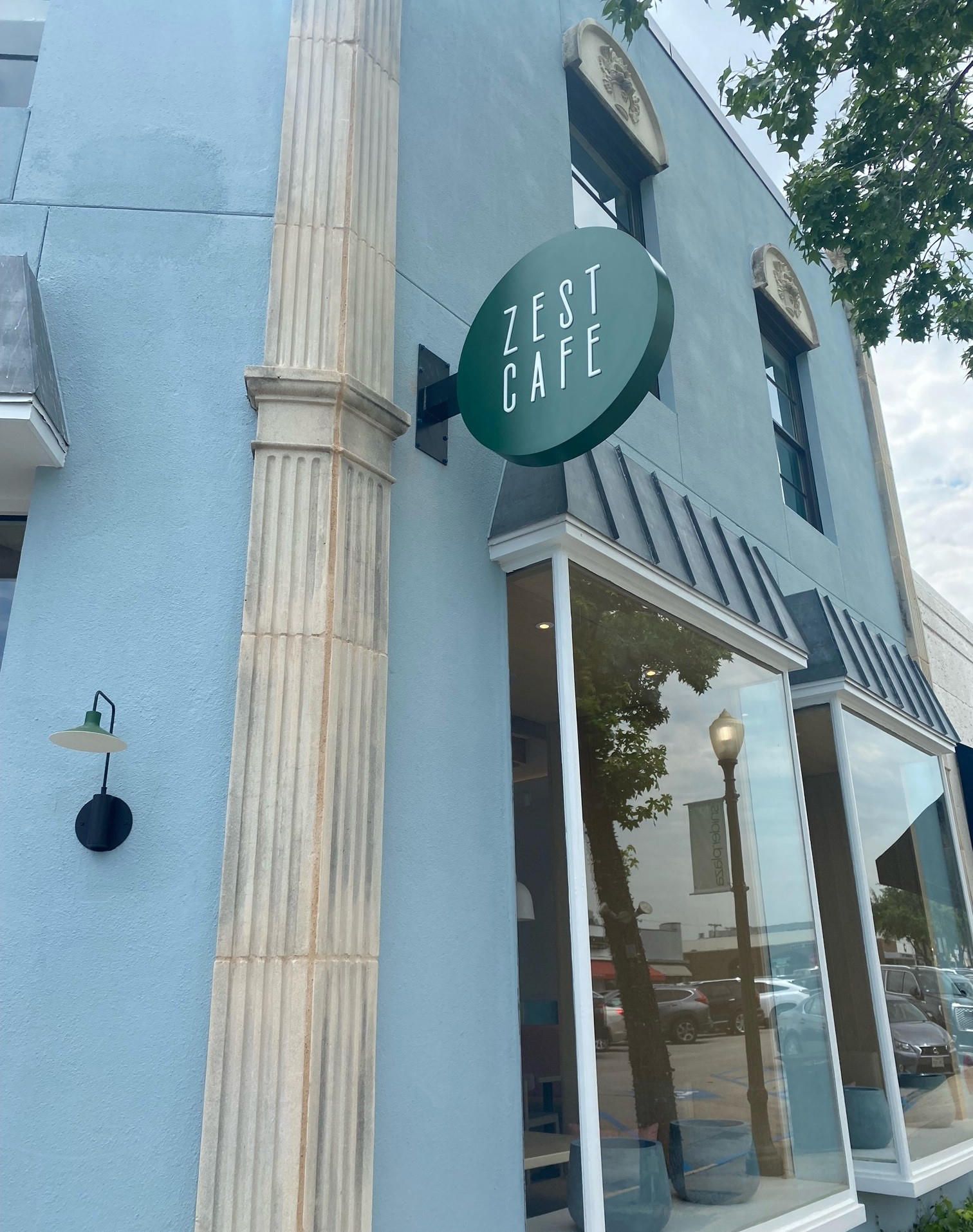 Round projecting blade sign for Zest Cafe in Dallas, TX.