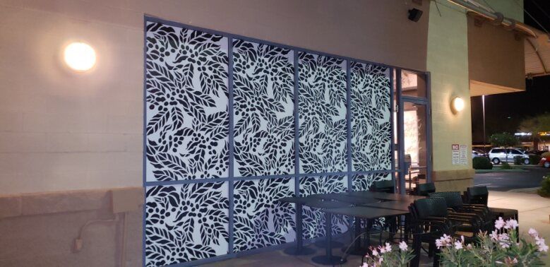 a glass wall with a pattern of leaves on it