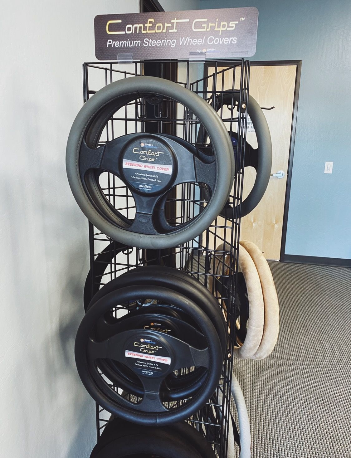 a display of steering wheel covers with a sign that says Comfort Grips