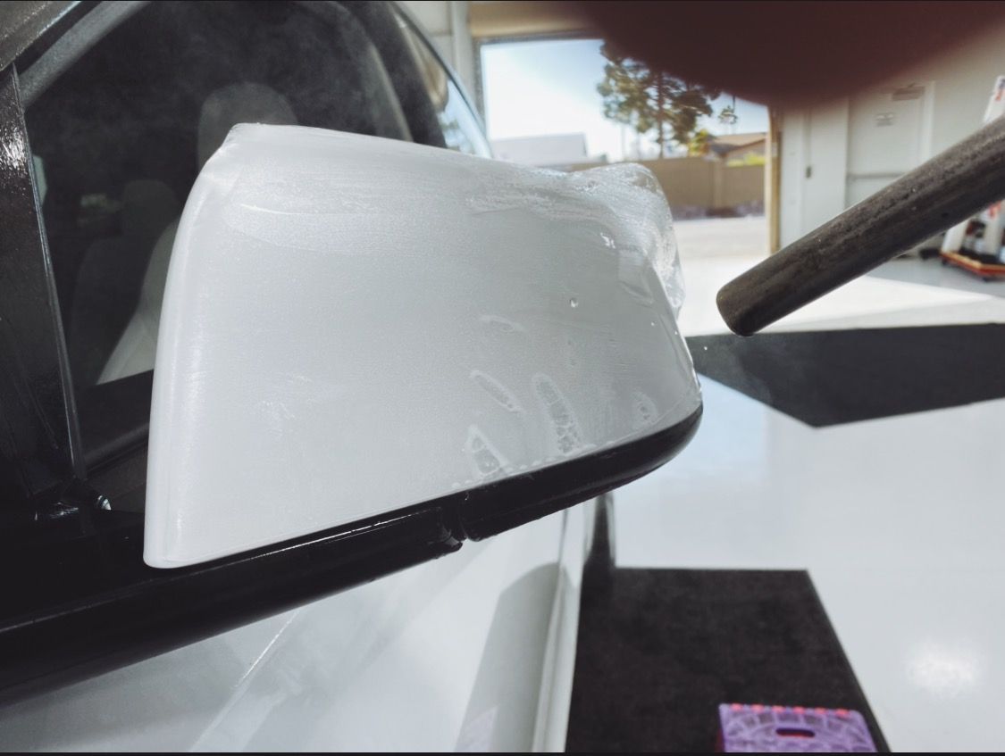 a close up of a white car 's side mirror