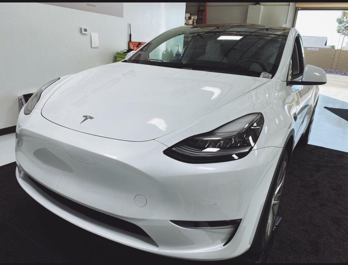 a white tesla is parked in a garage