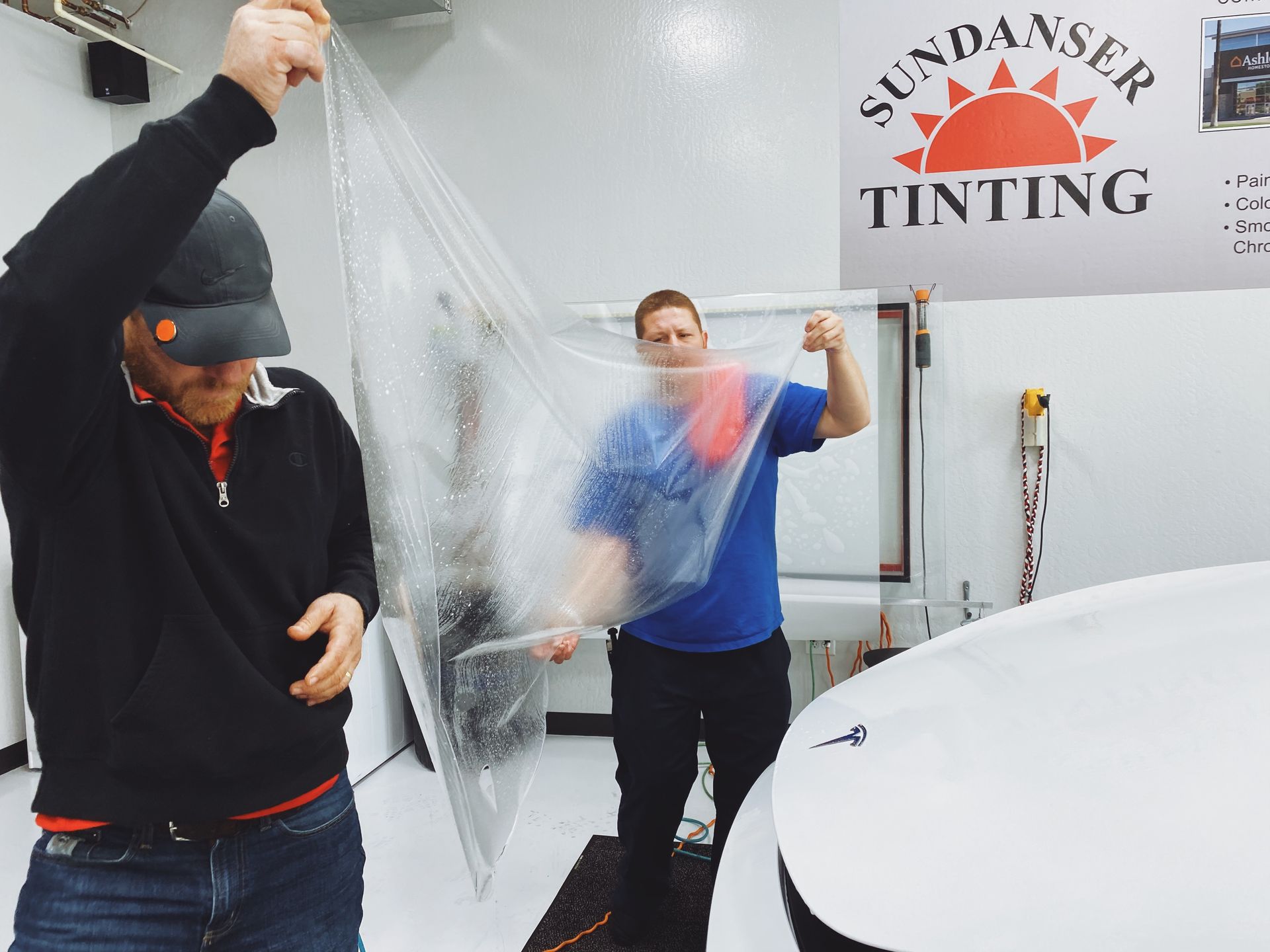 two men applying protective film on a car