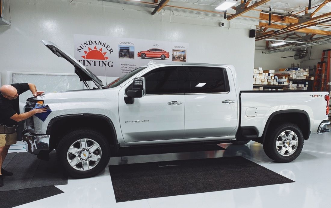 a man is working on a white truck in a garage