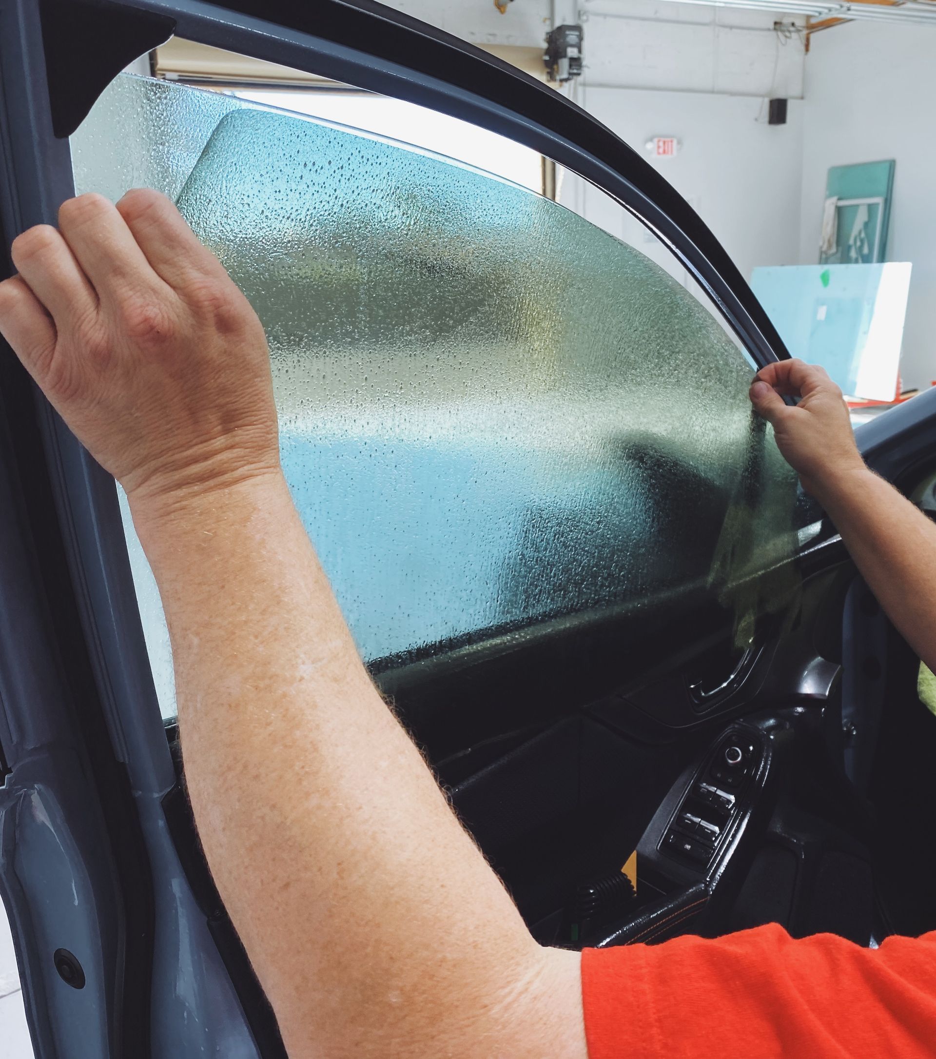 a person is applying tint to a car window