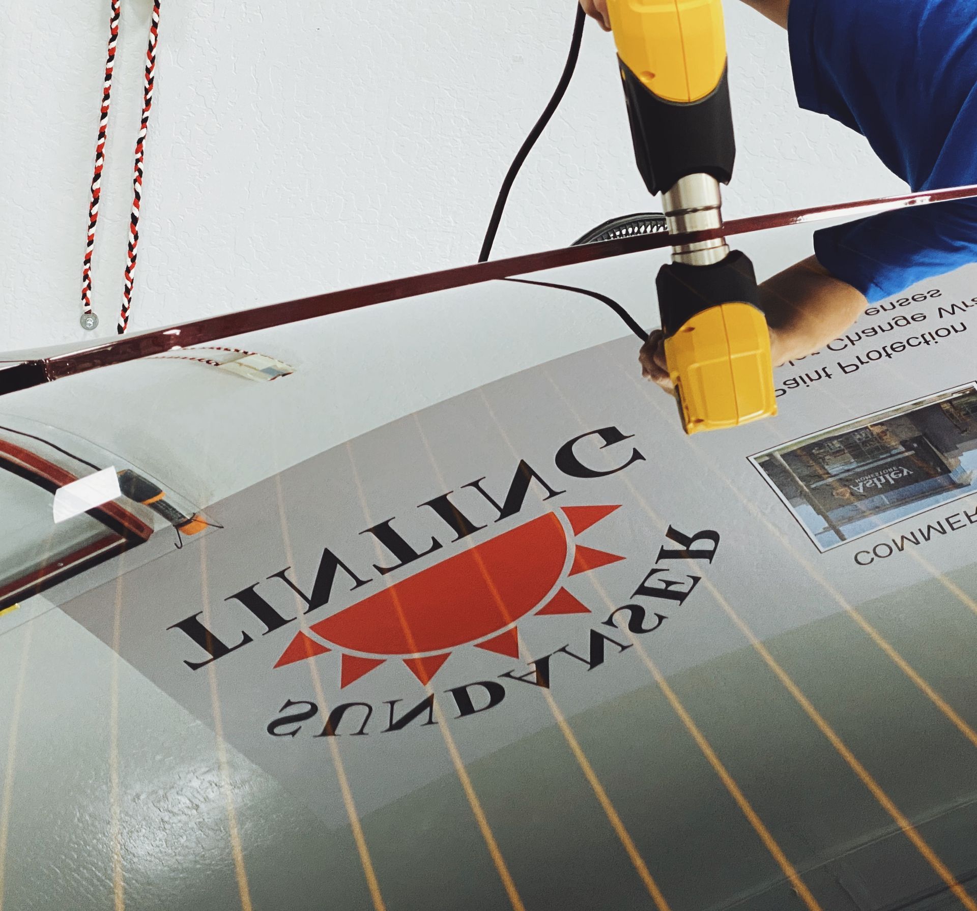 a person using heat gun on a tint application