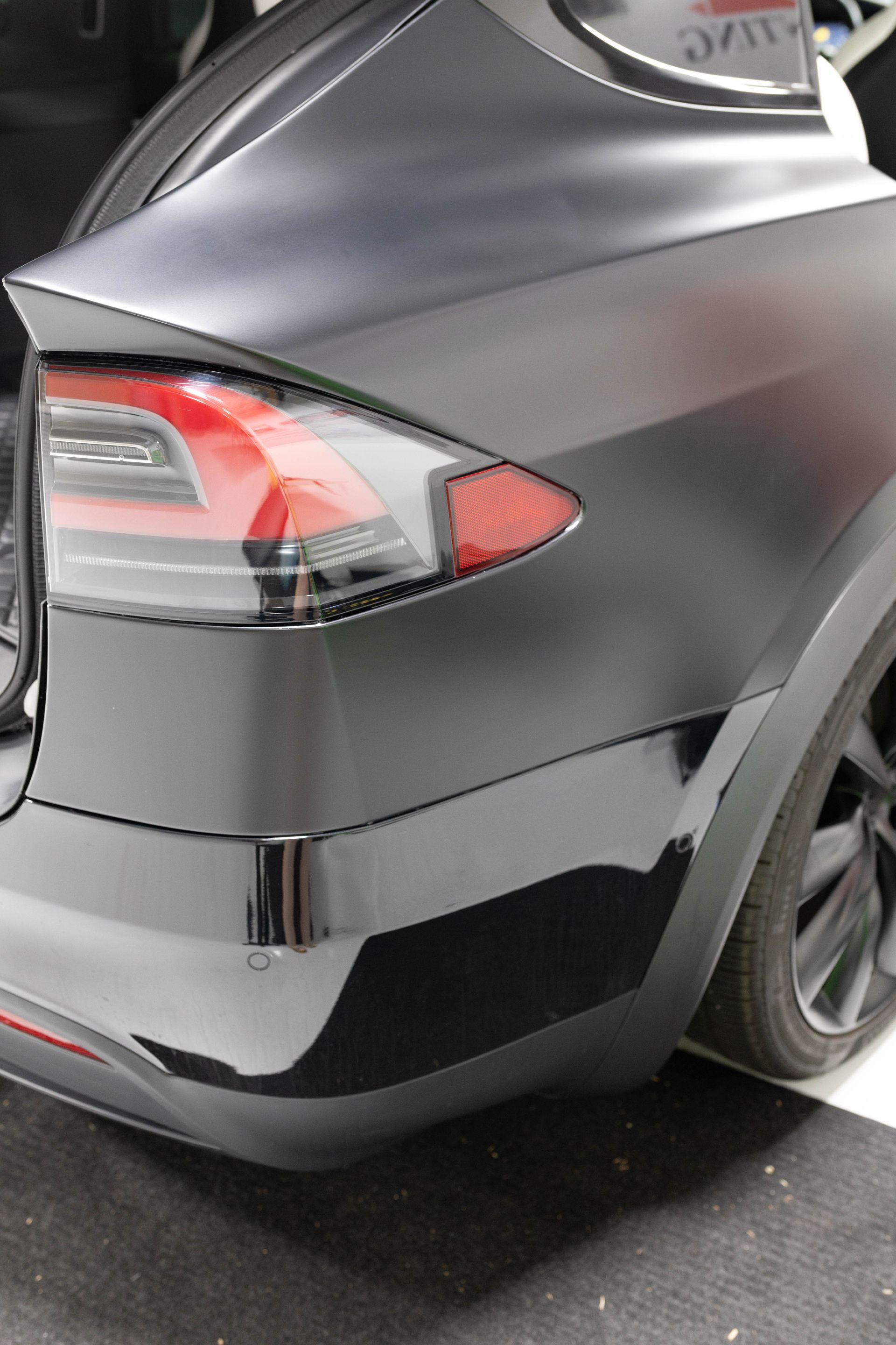 a black tesla is parked in a garage