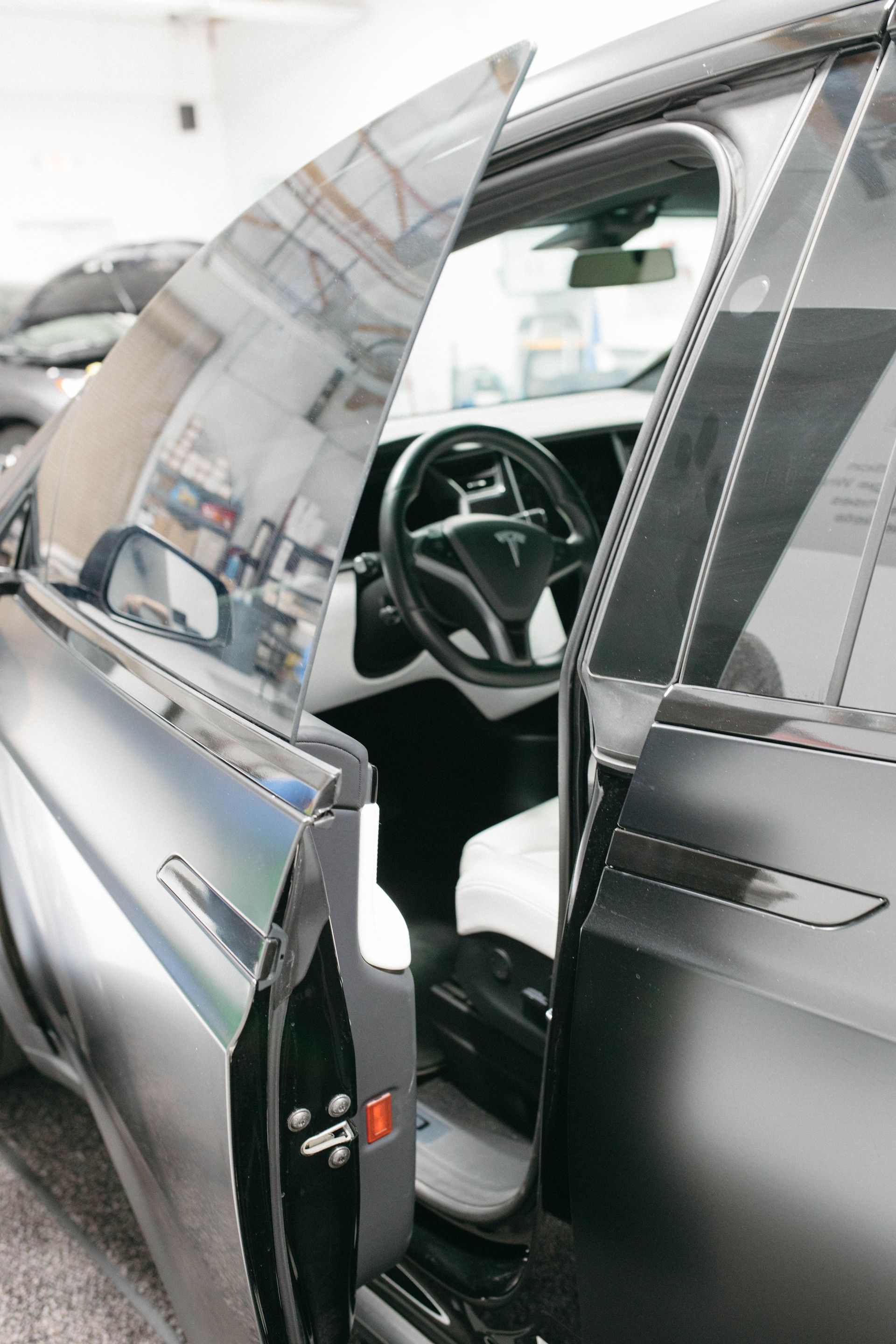 a tesla is parked in a garage with the door open