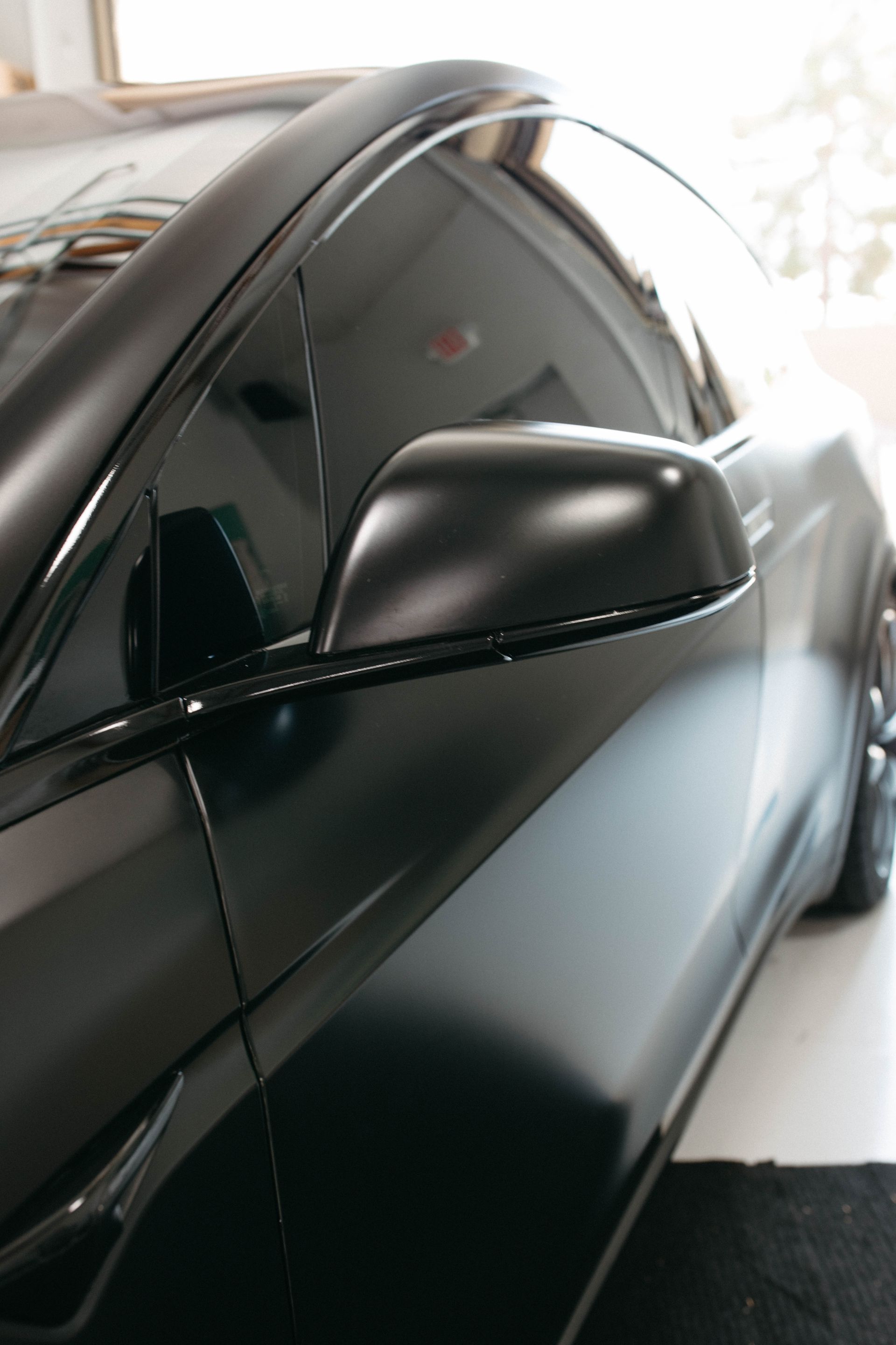 a black tesla is parked in a garage