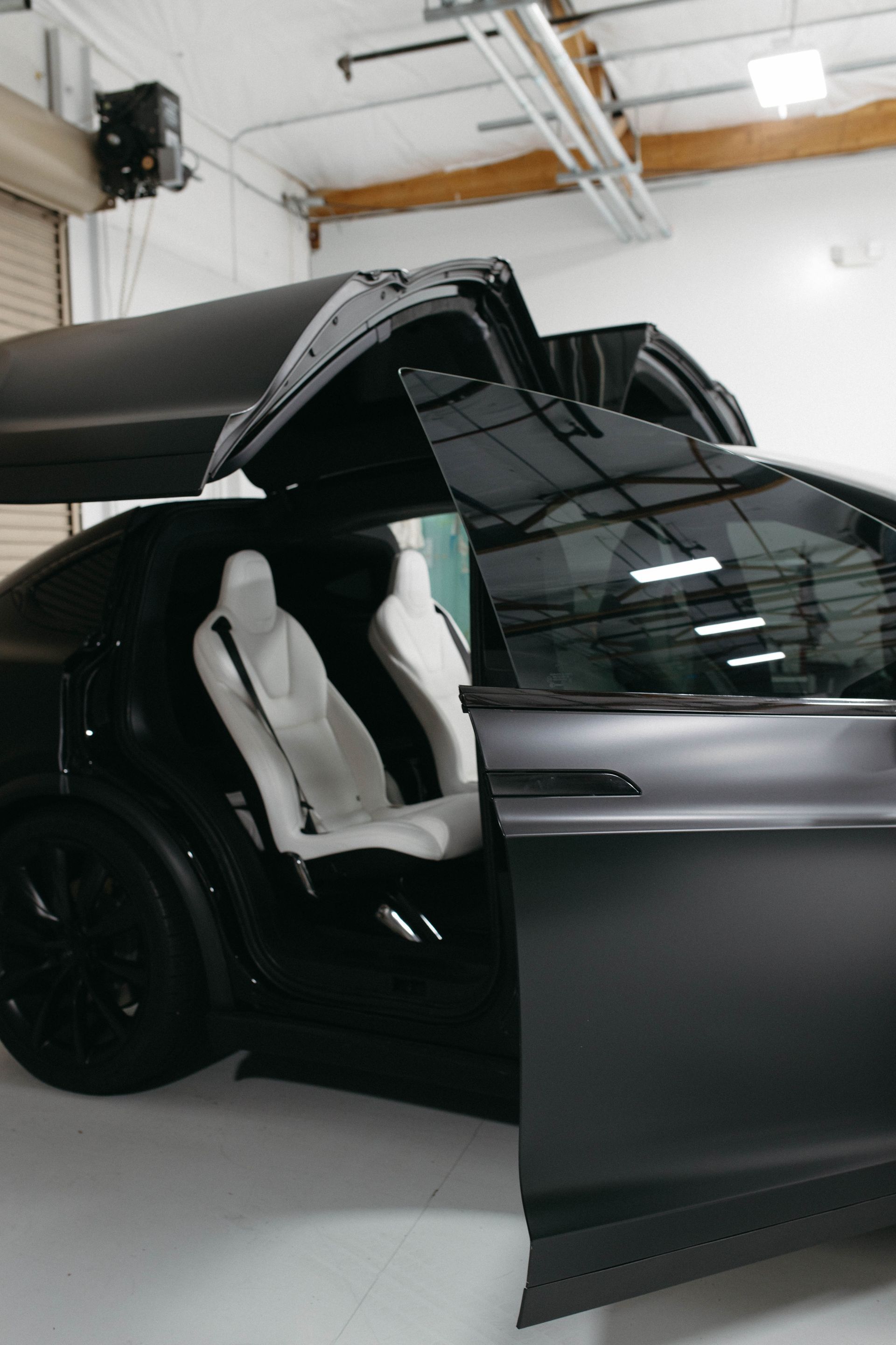 a tesla is parked in a garage with its doors open