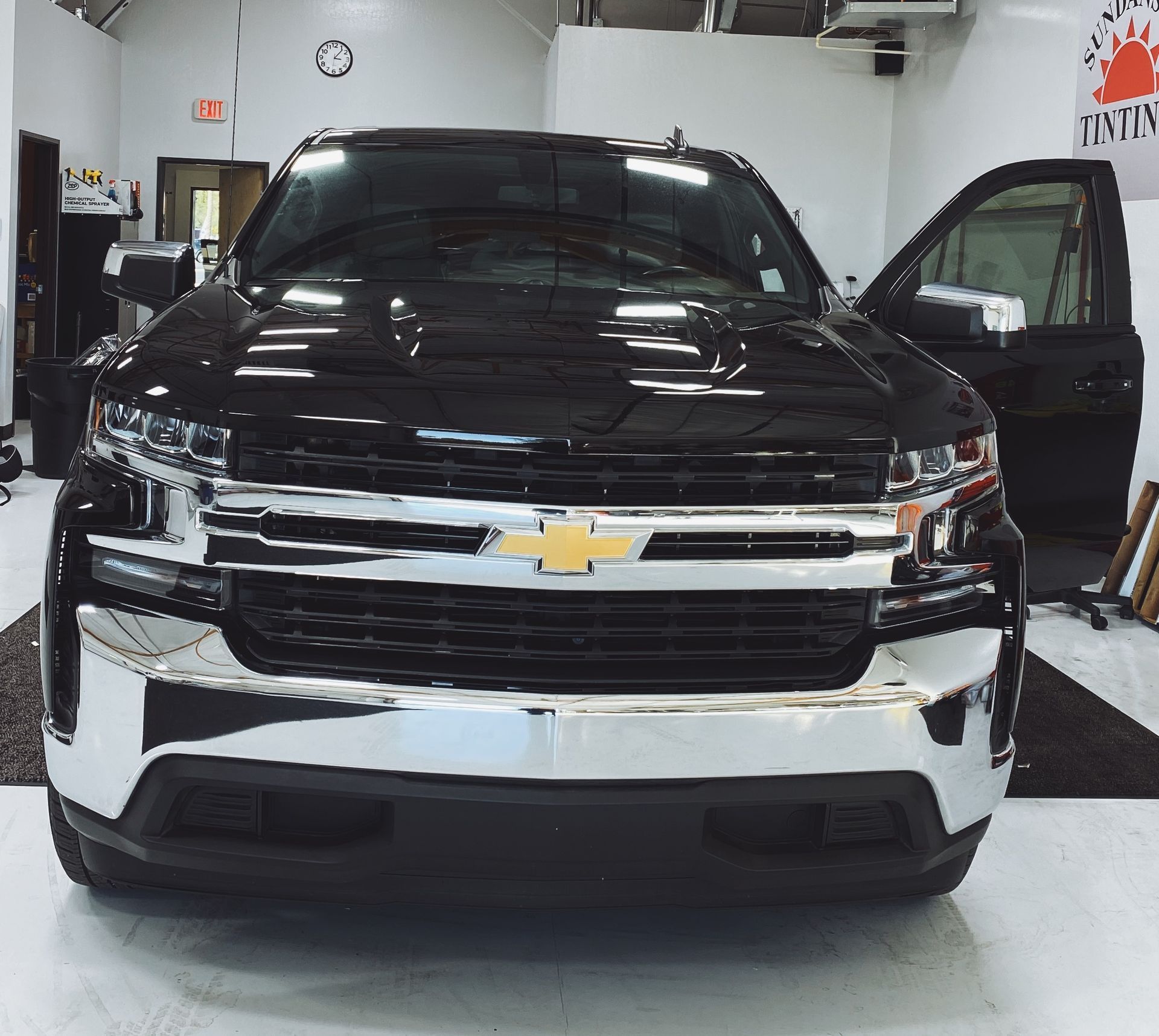 a black chevrolet truck is parked in a garage