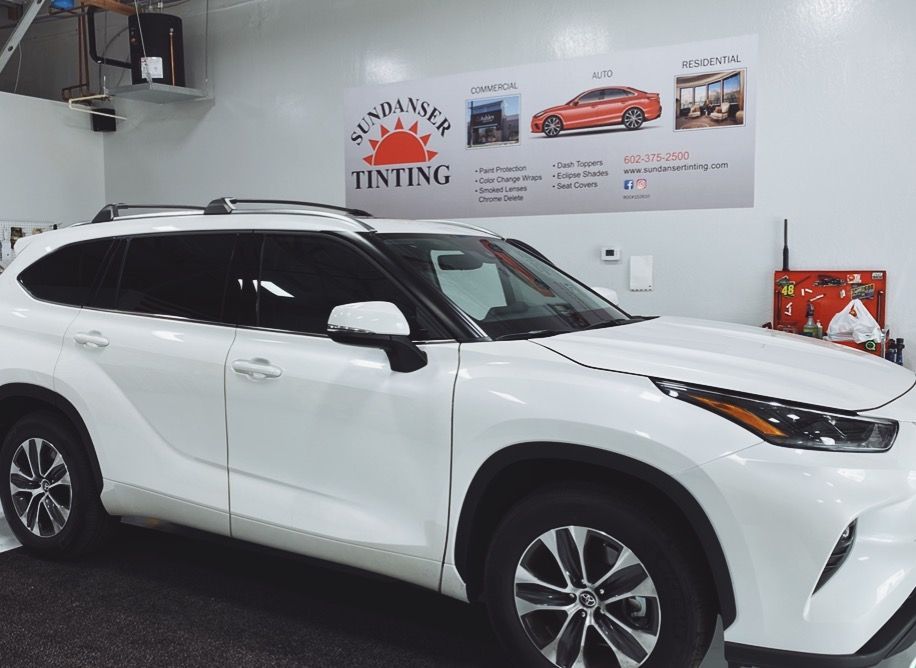 a white suv is parked in front of a sign