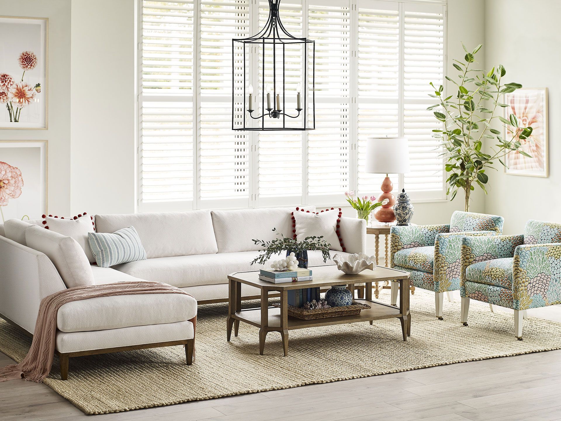 A living room with a couch , chairs , coffee table and rug.
