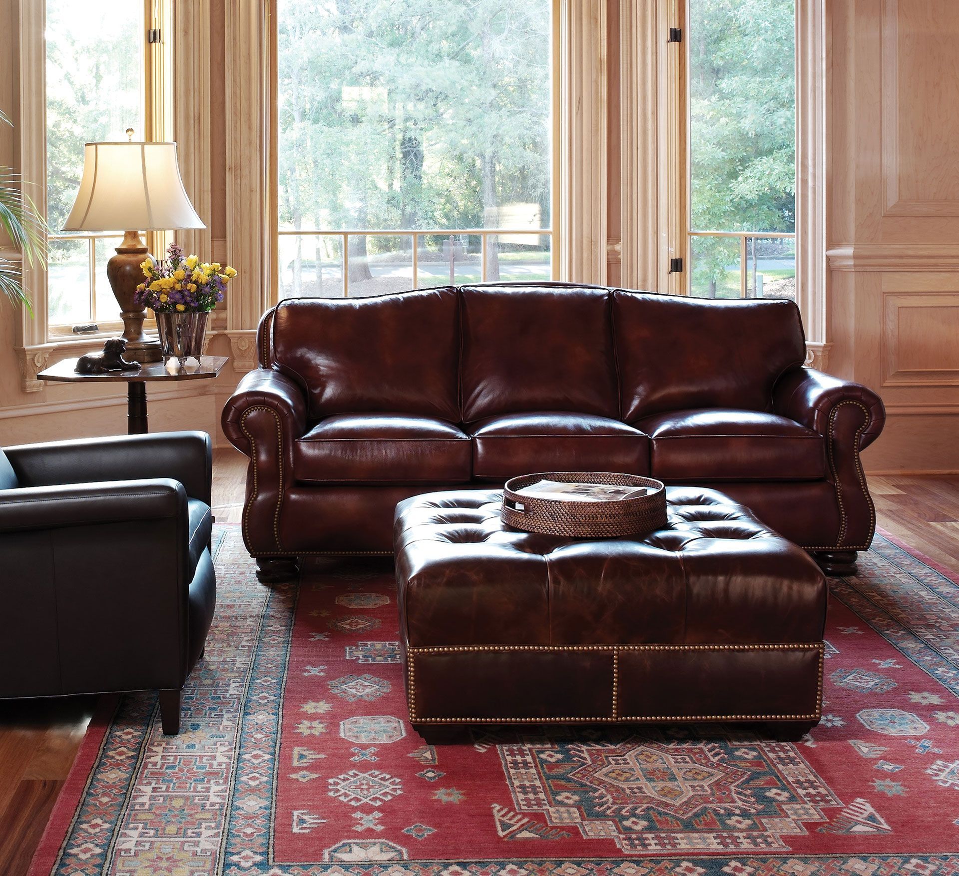 A living room with a brown leather couch and ottoman