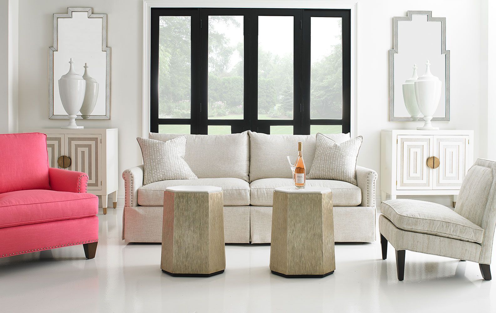 A living room with a couch , chairs , tables and a mirror.