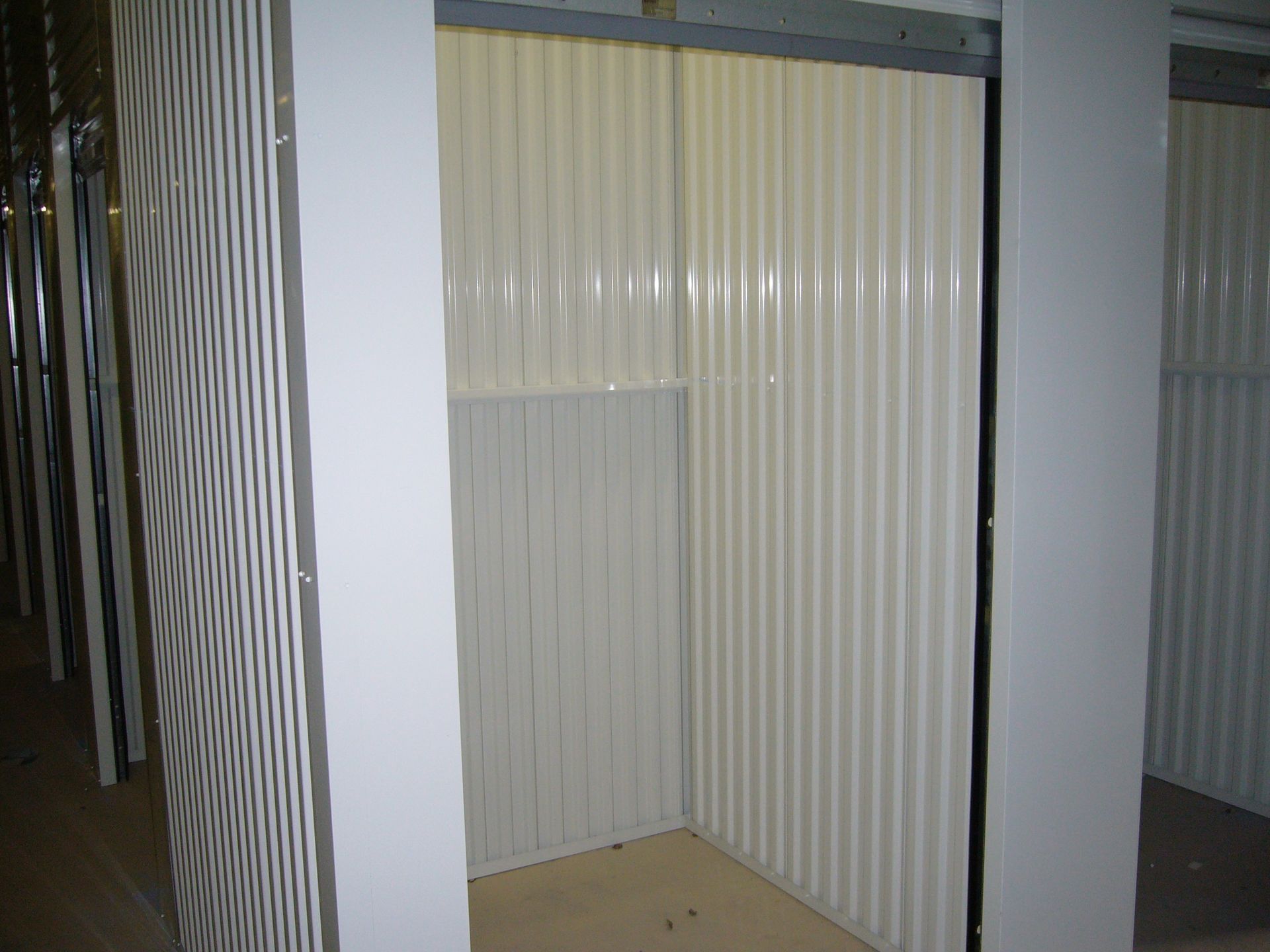 An empty room with a white wall and a door.
