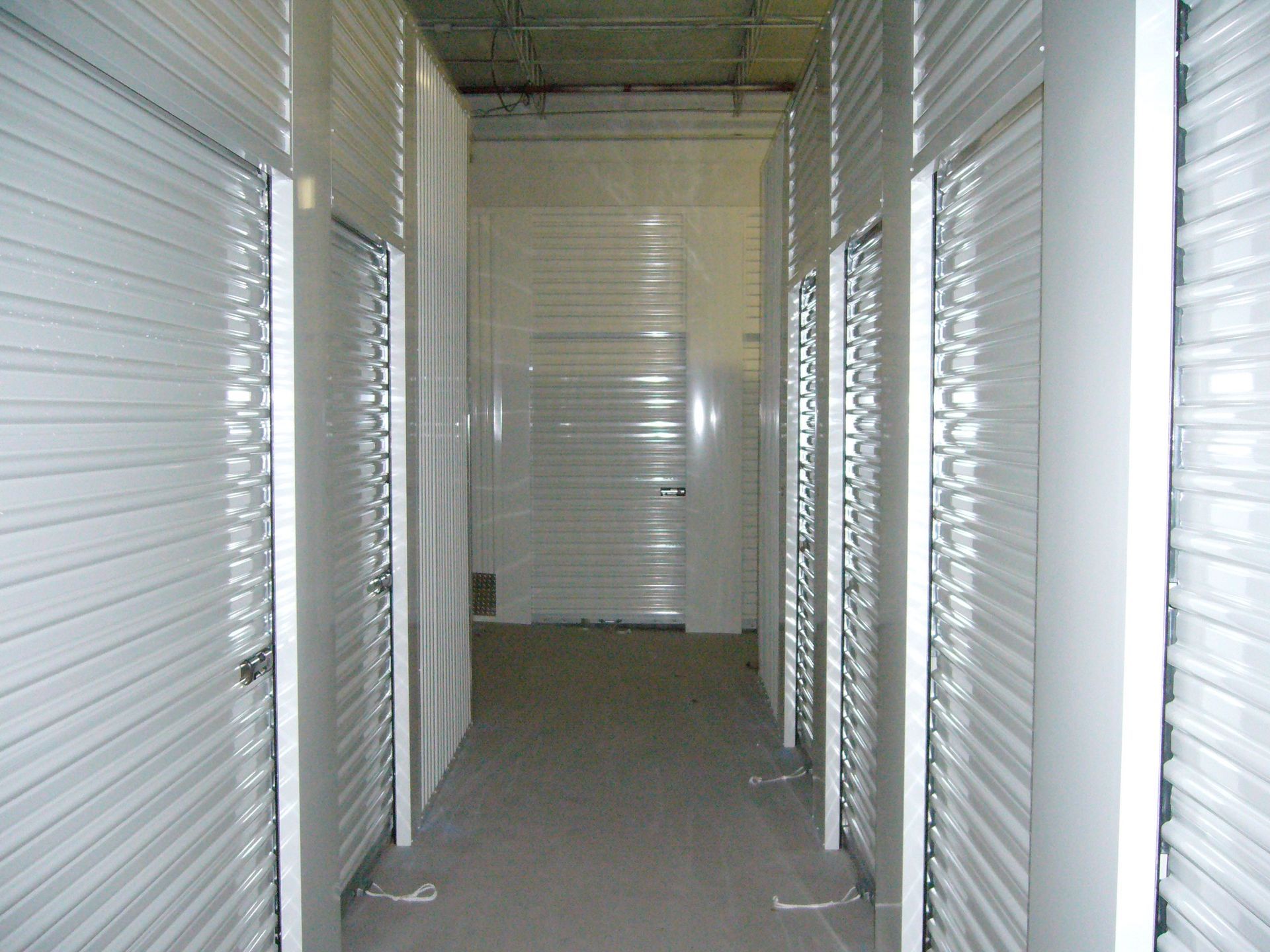 A hallway with a lot of doors and a white wall