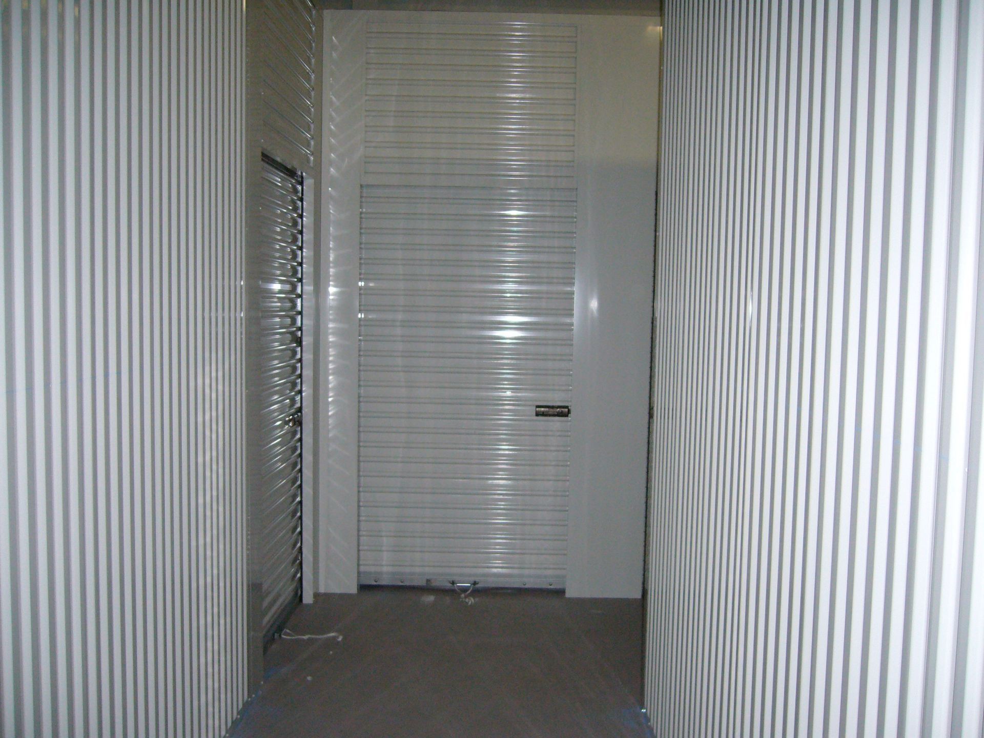 A hallway with striped walls and a white door