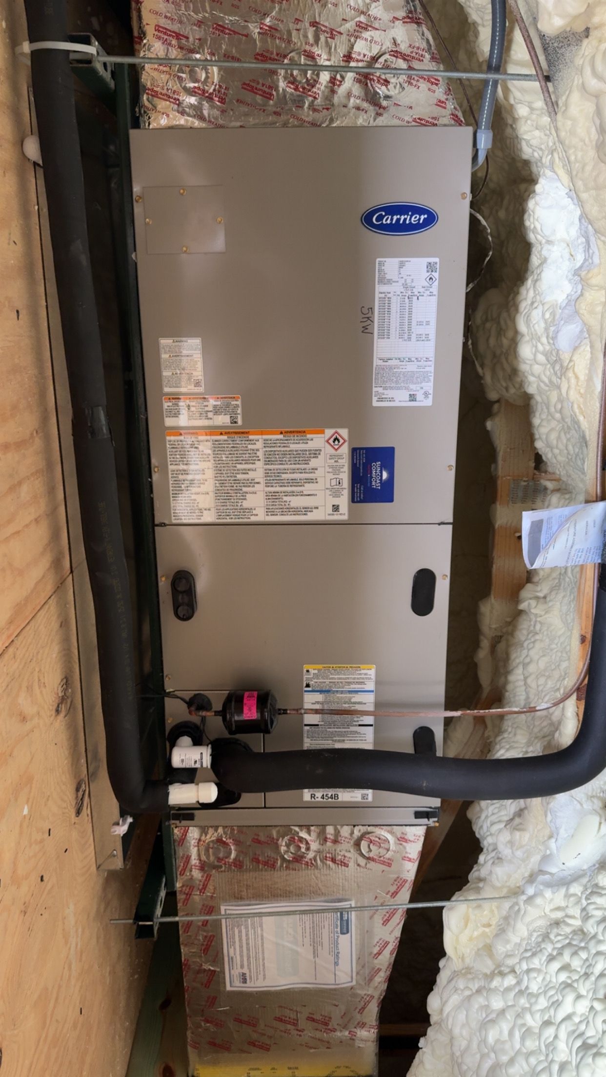 Carrier HVAC unit installed inside a wall cavity with insulated ductwork.