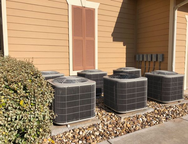 Air conditioning units outside a building, covered in black material.