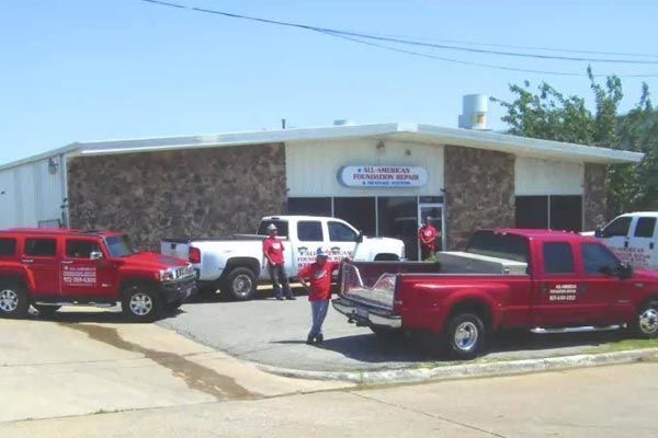 Several red trucks are parked in front of a building