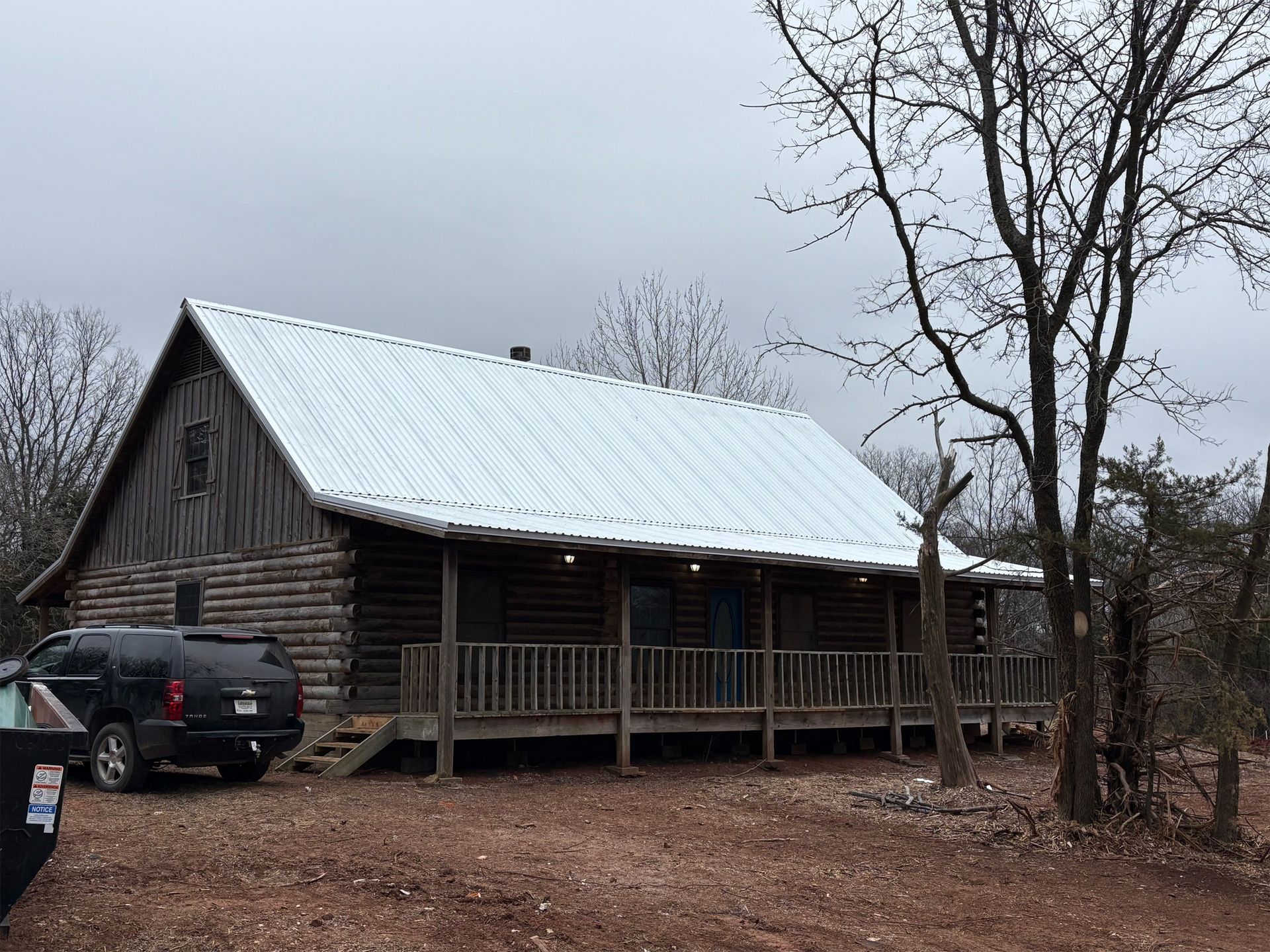 A log cabin with a car parked in front of it