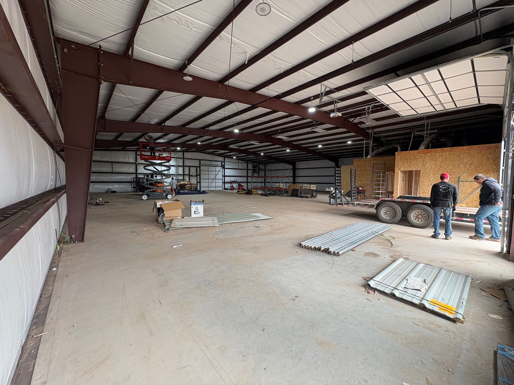 Two men are standing inside of a large warehouse.