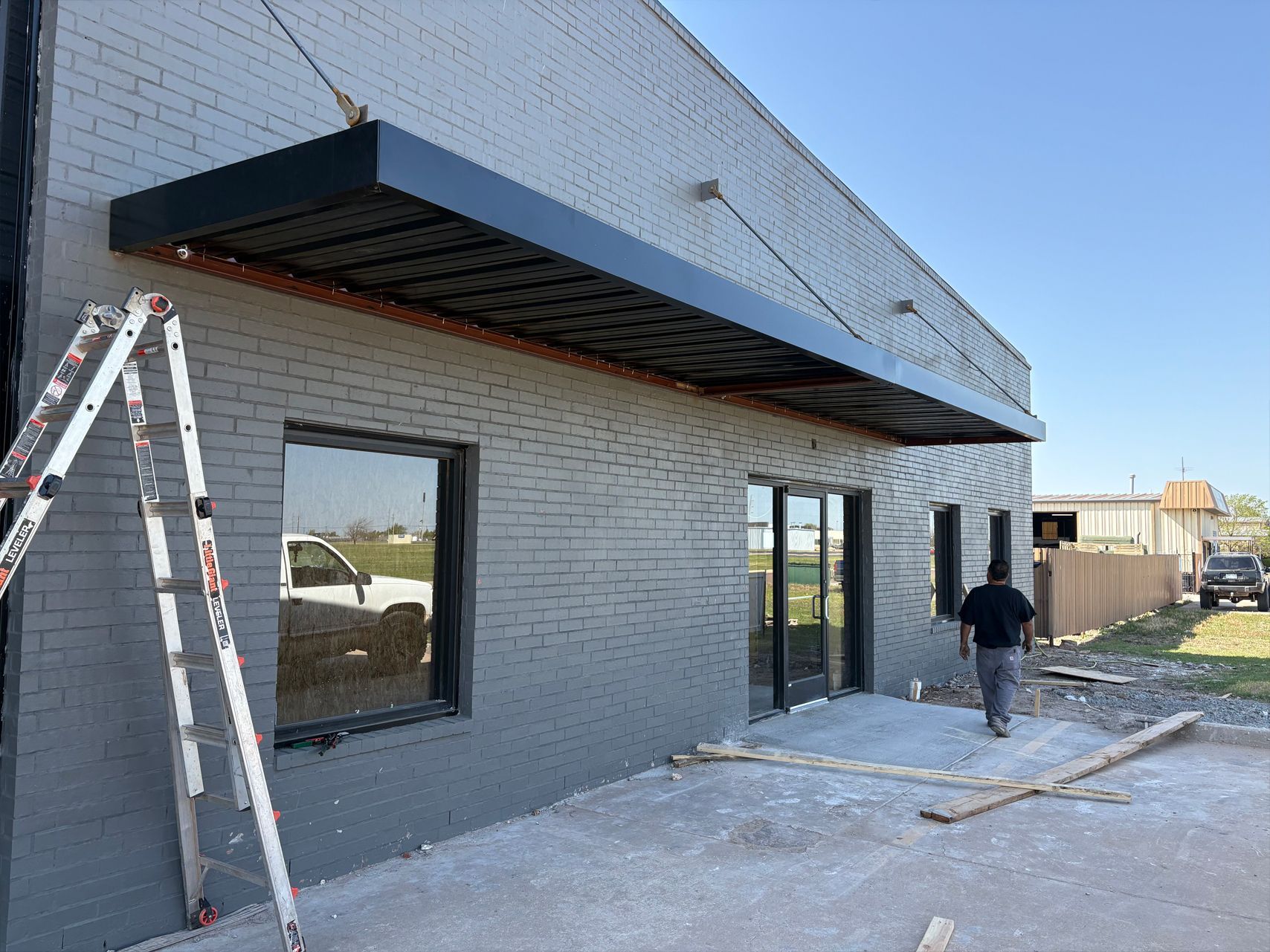 A man is standing in front of a building with a canopy.