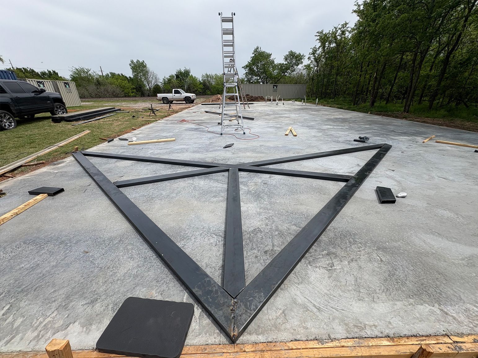 A concrete floor with a triangle in the middle and a ladder in the background.