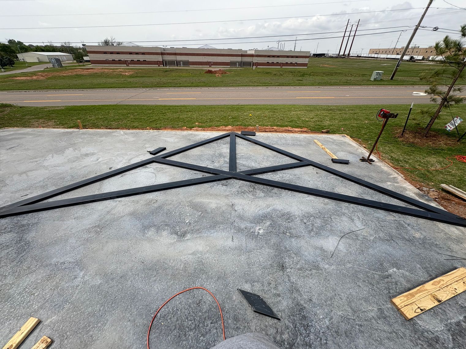 A metal structure is being built on a concrete surface.