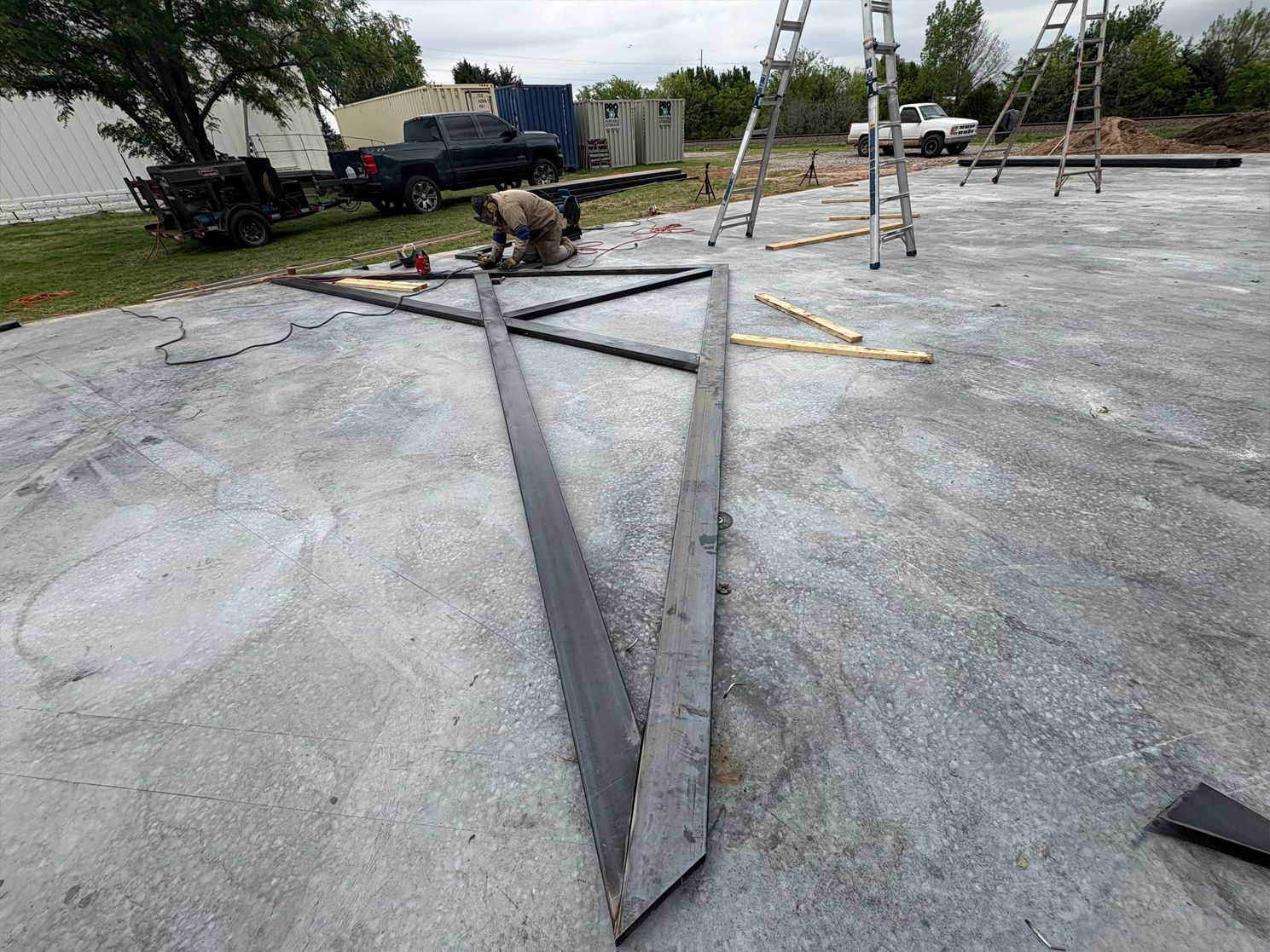 A man is working on a metal structure on the ground.