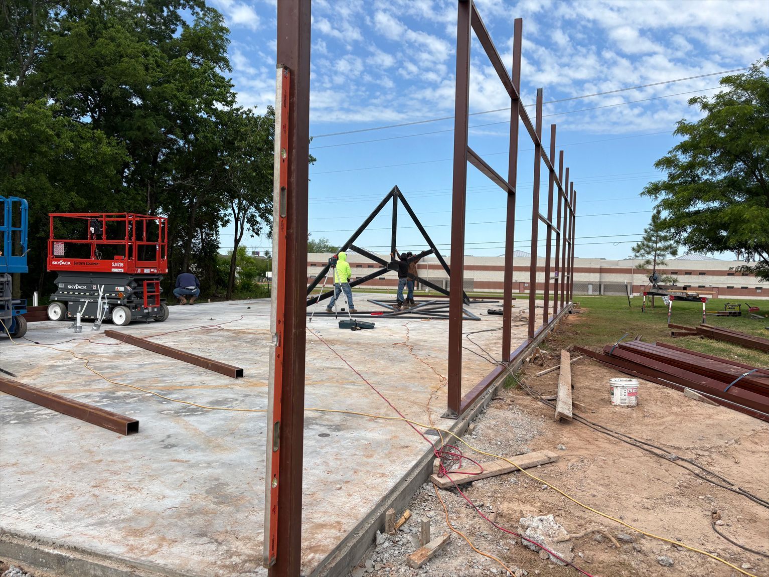 A group of construction workers are working on a metal structure.