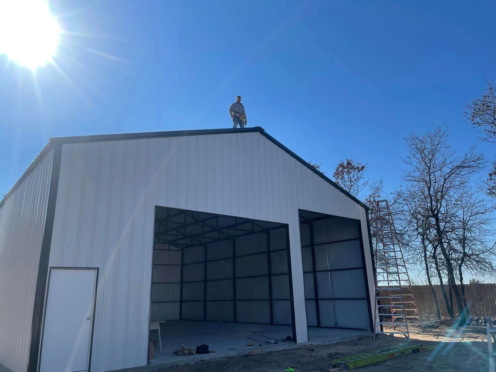 A man is standing on top of a large white building.