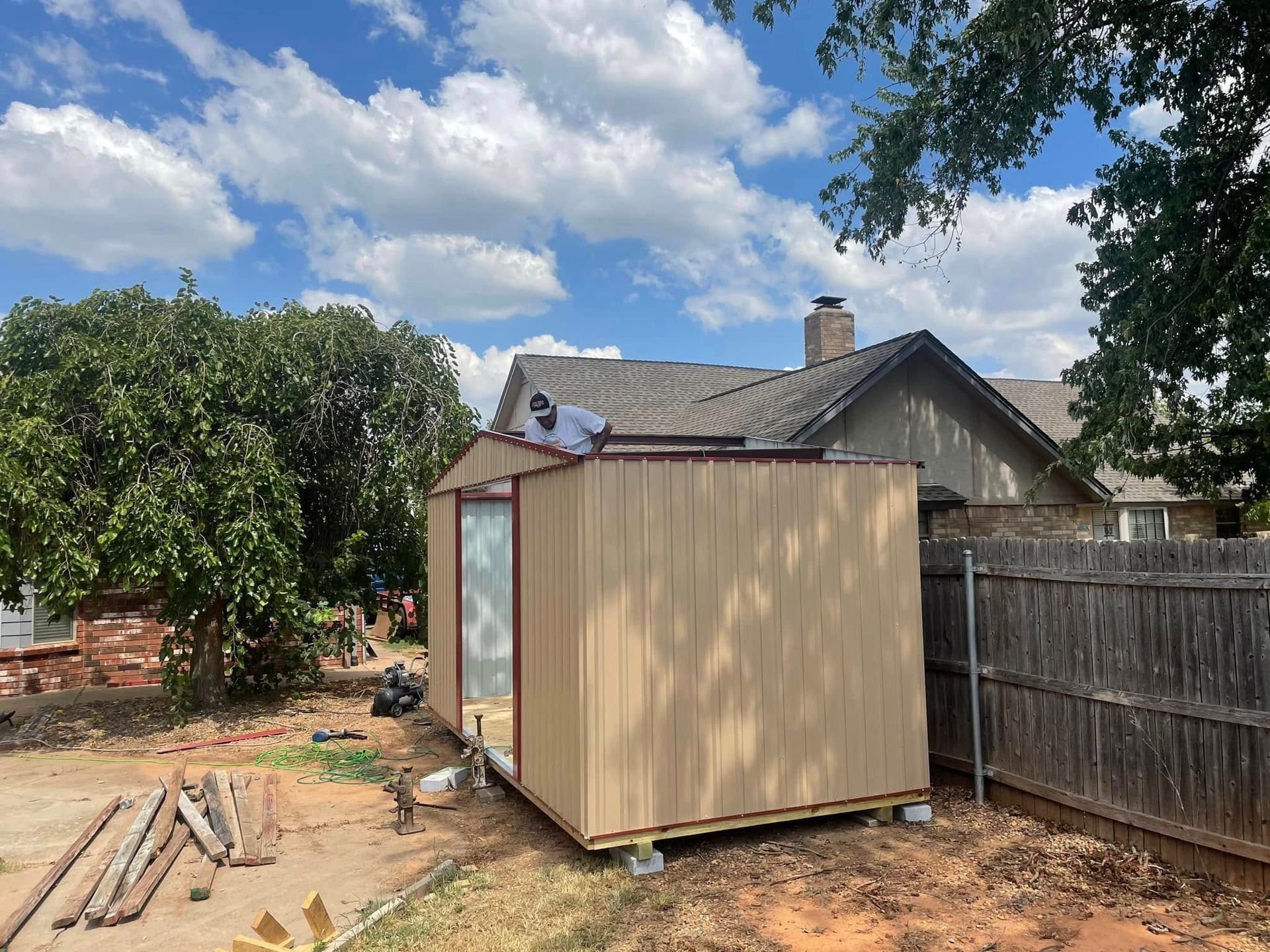 A shed is being built in the backyard of a house.