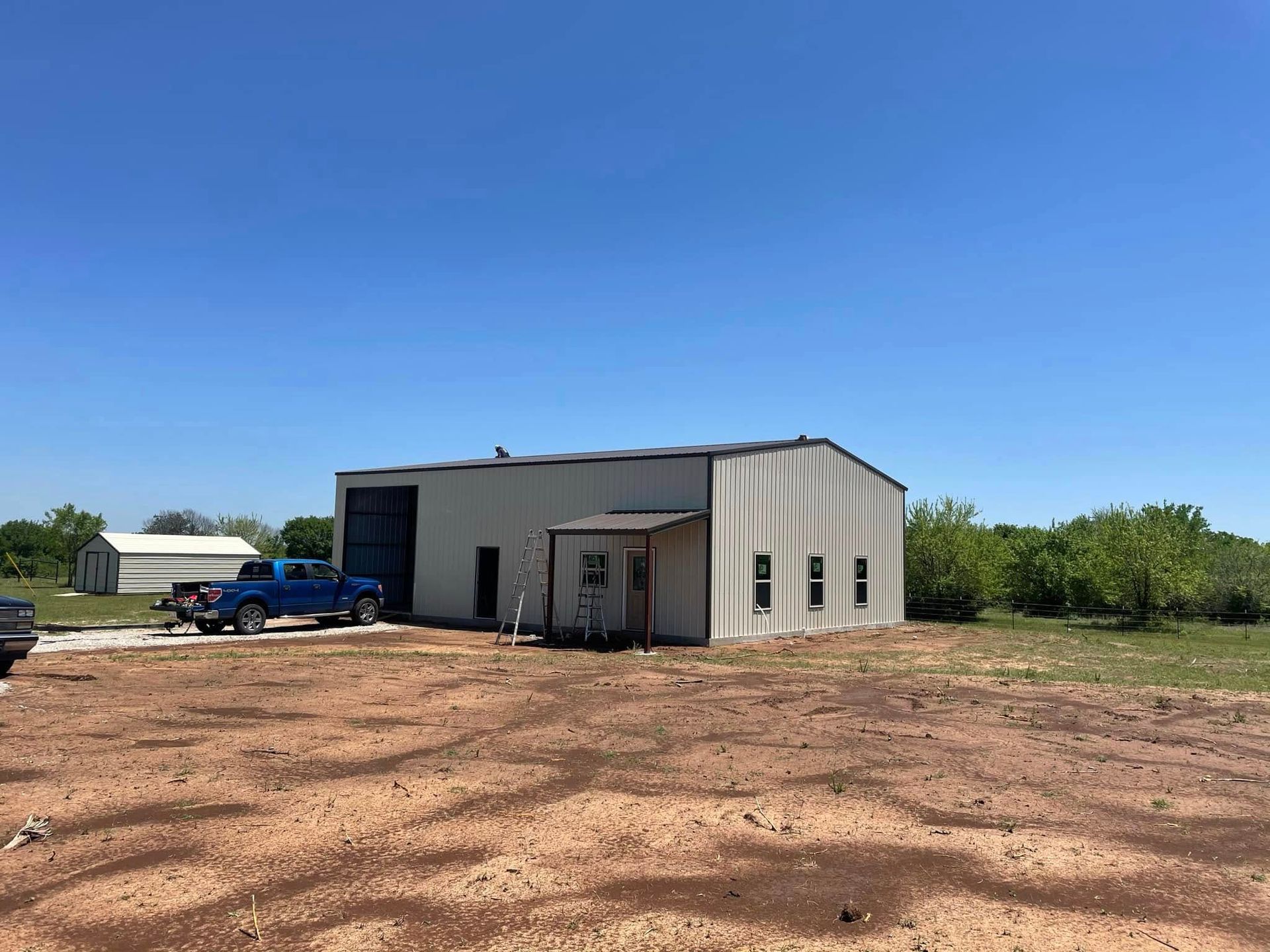 A blue truck is parked in front of a large building
