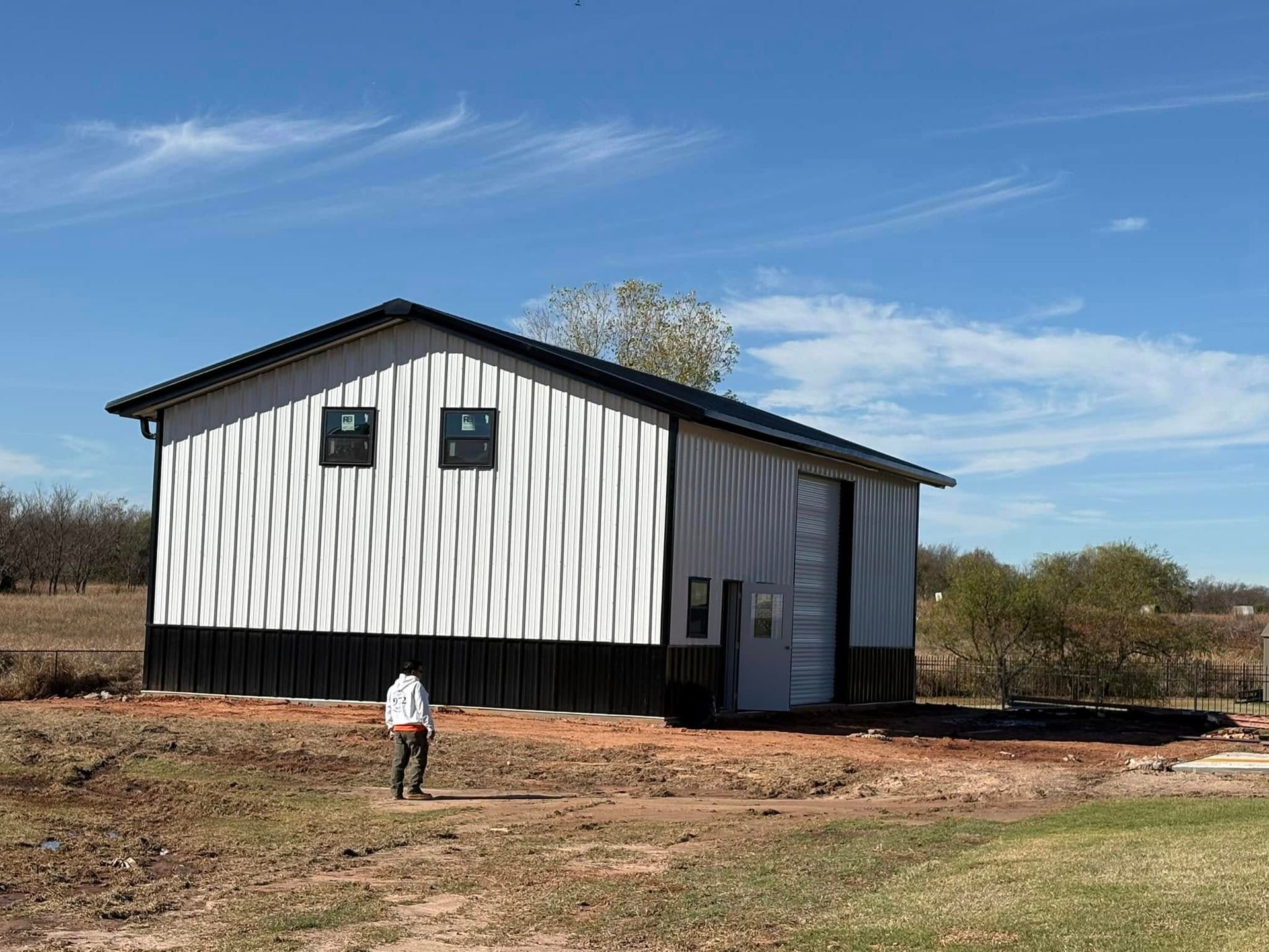 A man is standing in front of a white and black building.