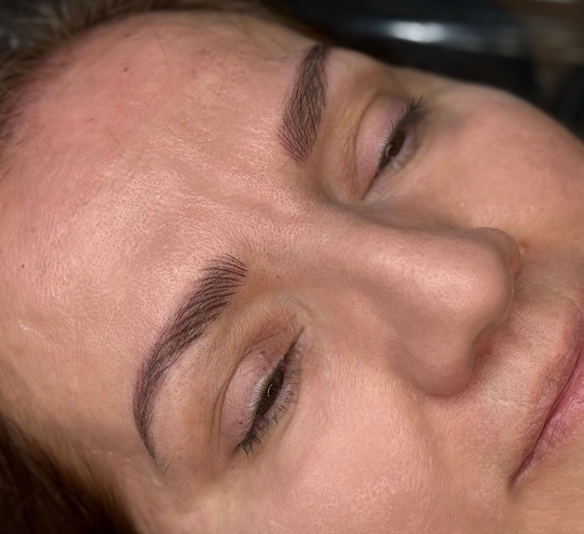 A close up of a woman's face with her eyes closed.