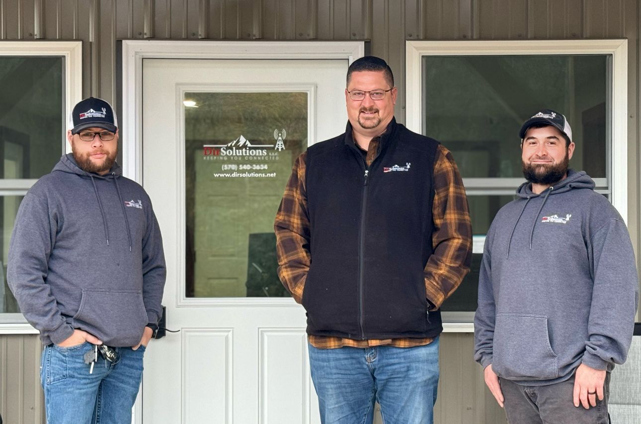 Three men are standing in front of a building.