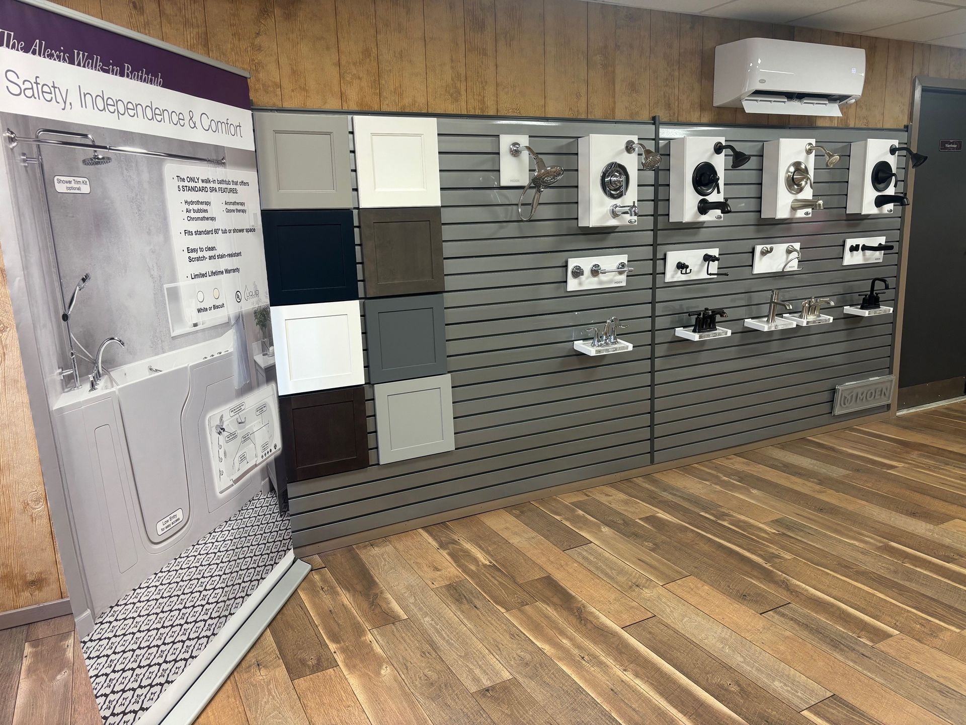 Display wall with electrical devices, switches, and panels in a wood-floored showroom.