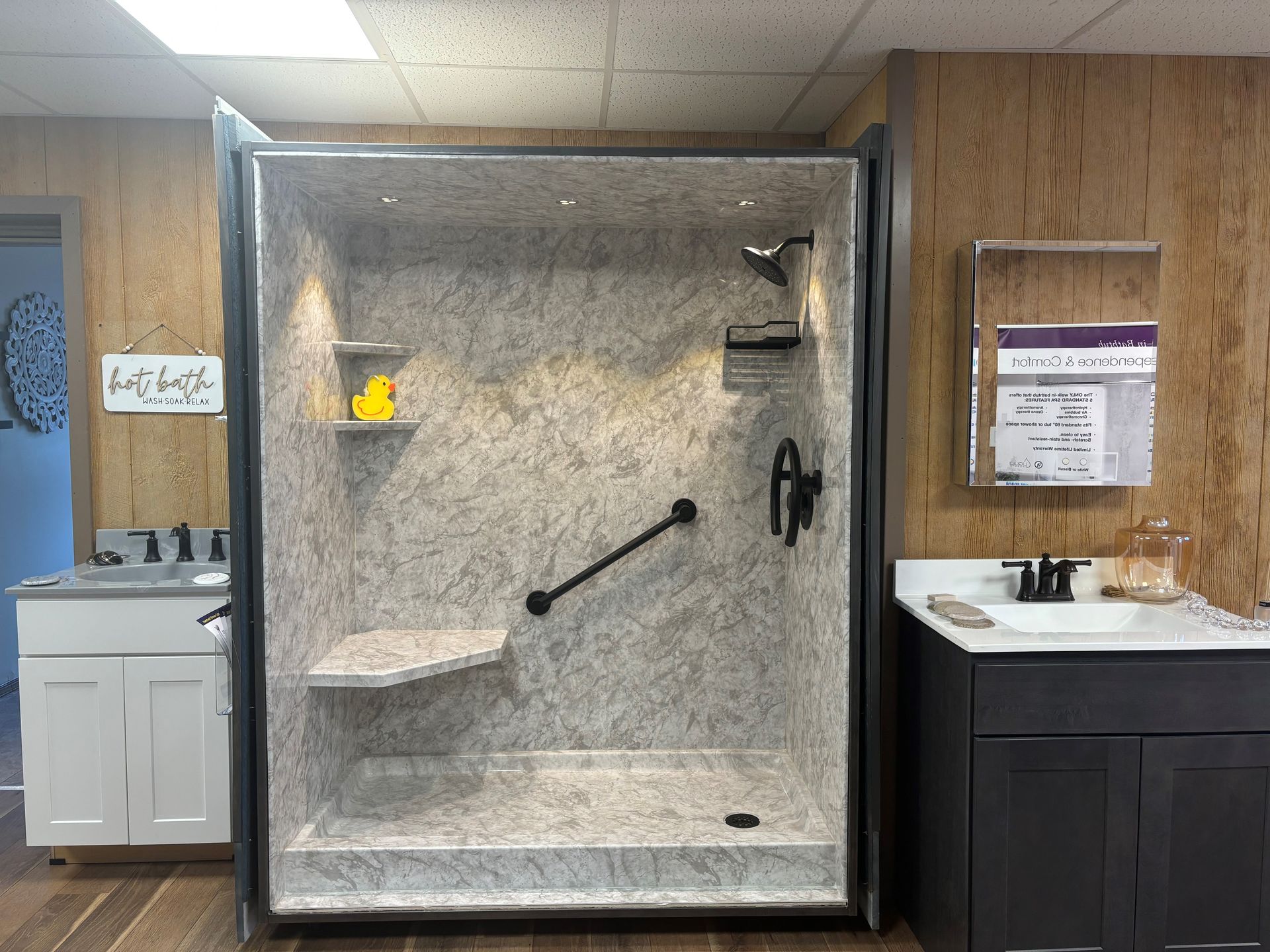 Accessible shower stall with grab bars, built-in bench, and shower controls in a tiled bathroom.