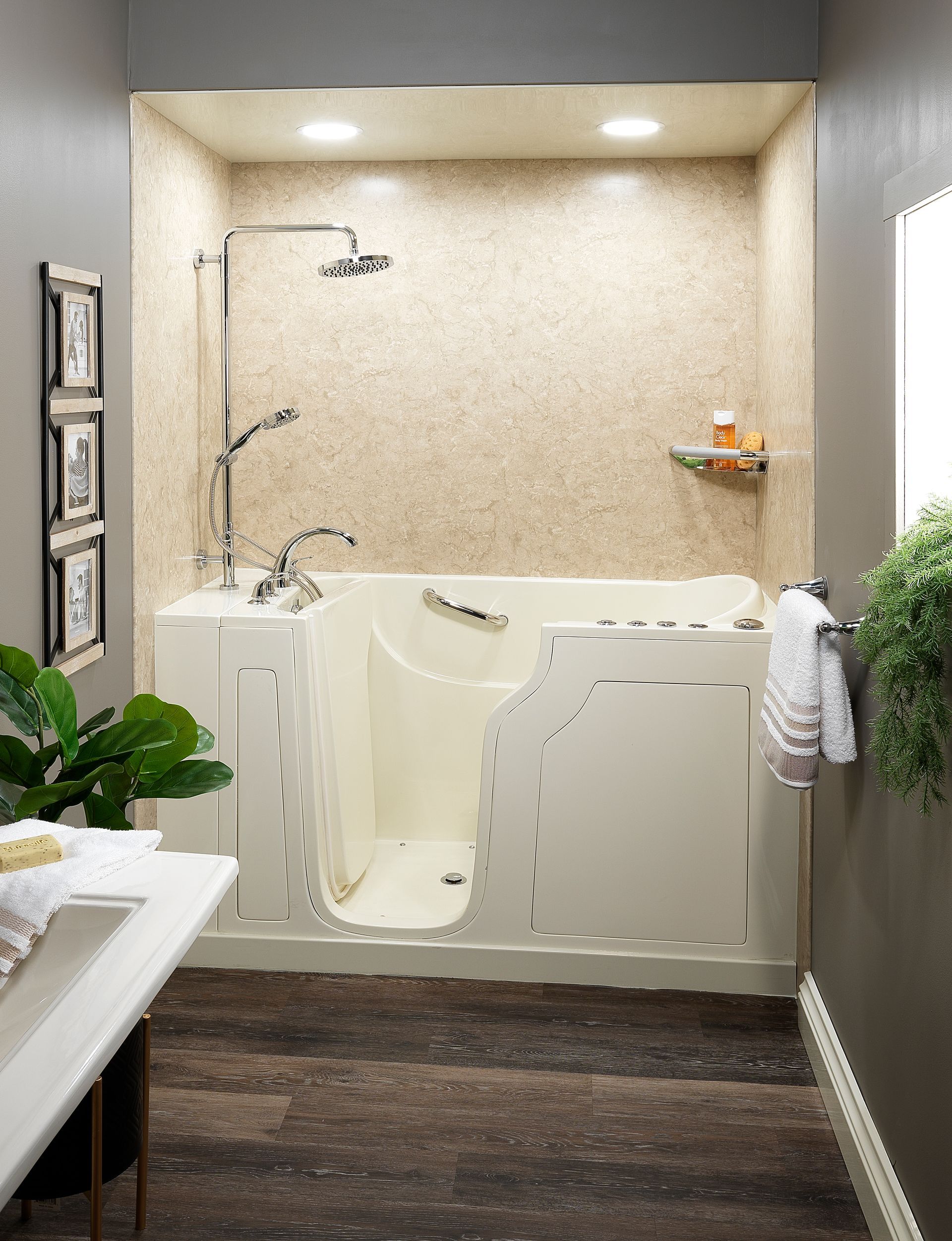 Accessible walk-in shower with white seat and beige tile surround in a bathroom