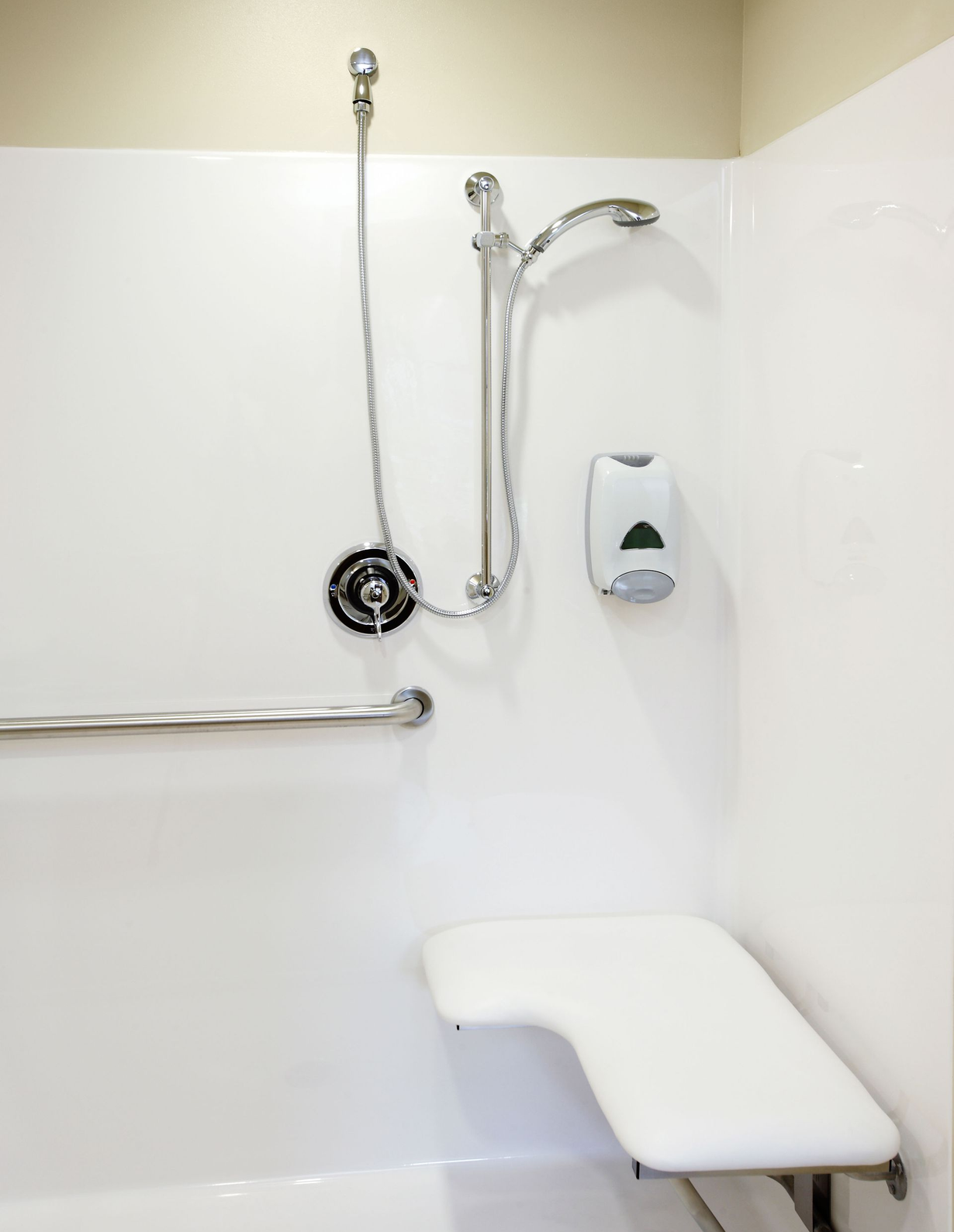Accessible bathroom with toilet, sink, grab bars, and tiled walls