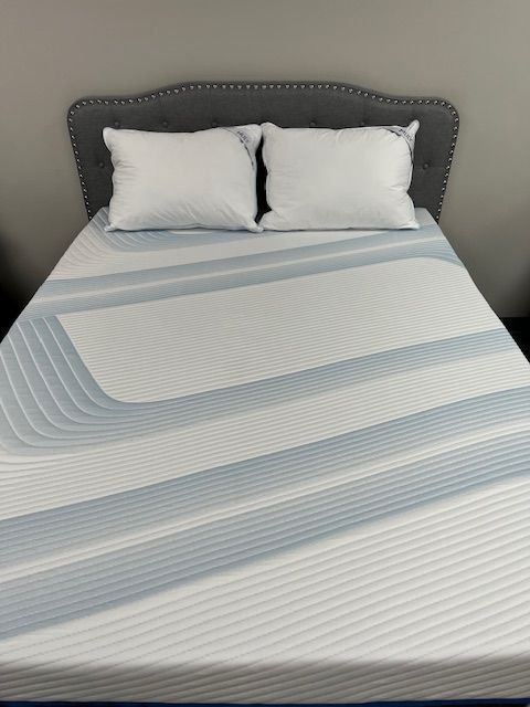 A bed with a mattress and pillows on it