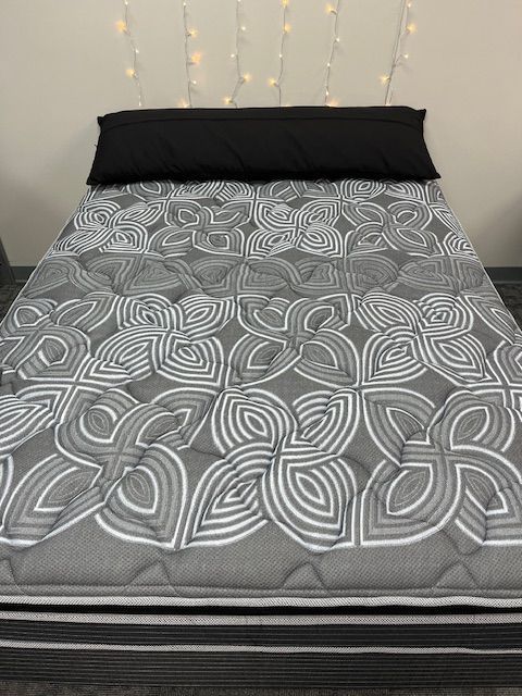 A bed with a mattress and two pillows on it