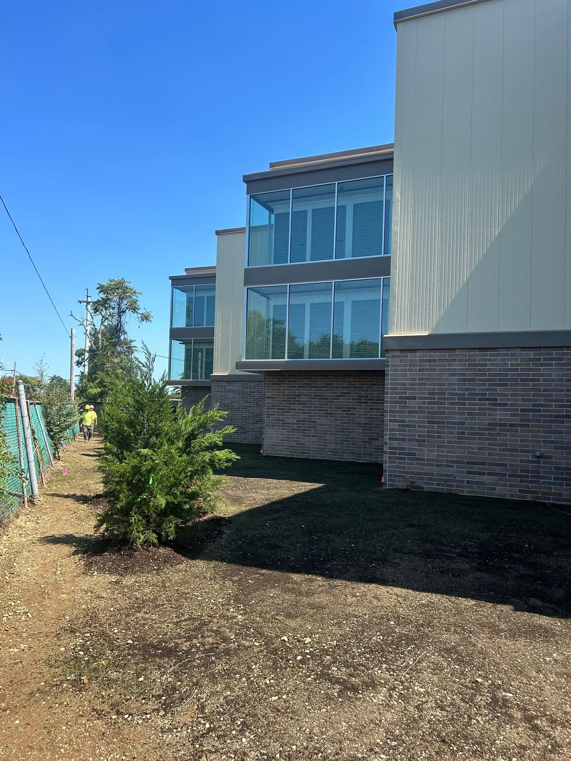 Modern multi-story building with glass balconies, on a sunny day.
