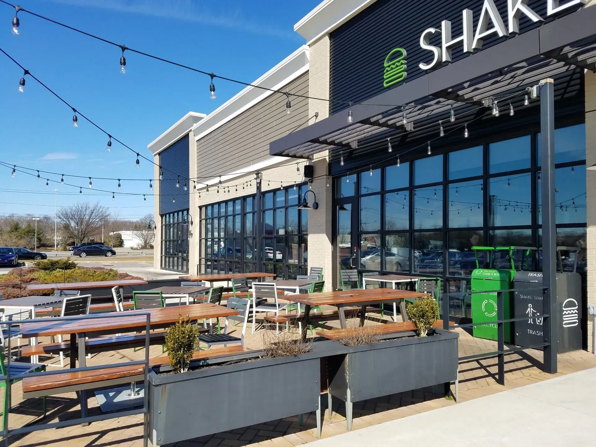 Shake Shack restaurant exterior with outdoor seating on a sunny day.